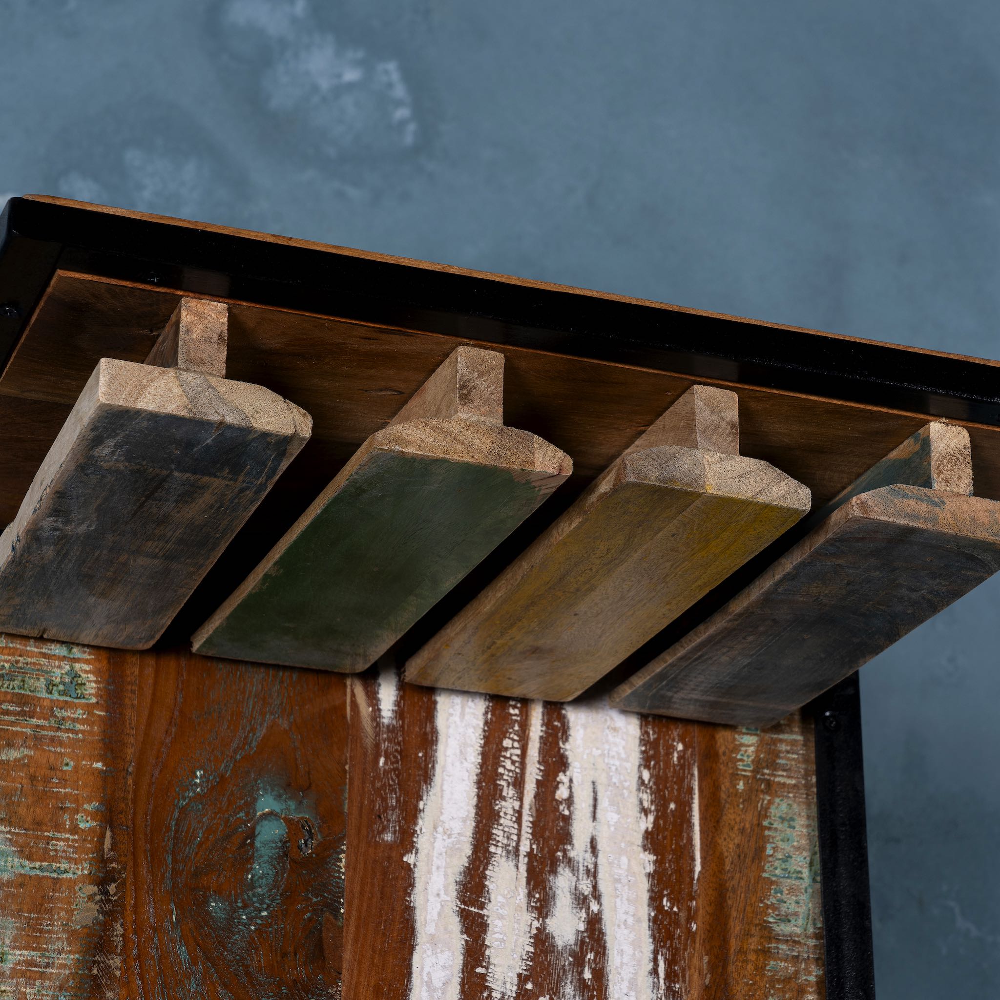Close up image of Ahana high bar table featuring the front half of a vintage Bajaj scooter, with tall wooden shelving and an industrial metal frame, designed for stylish bar storage.