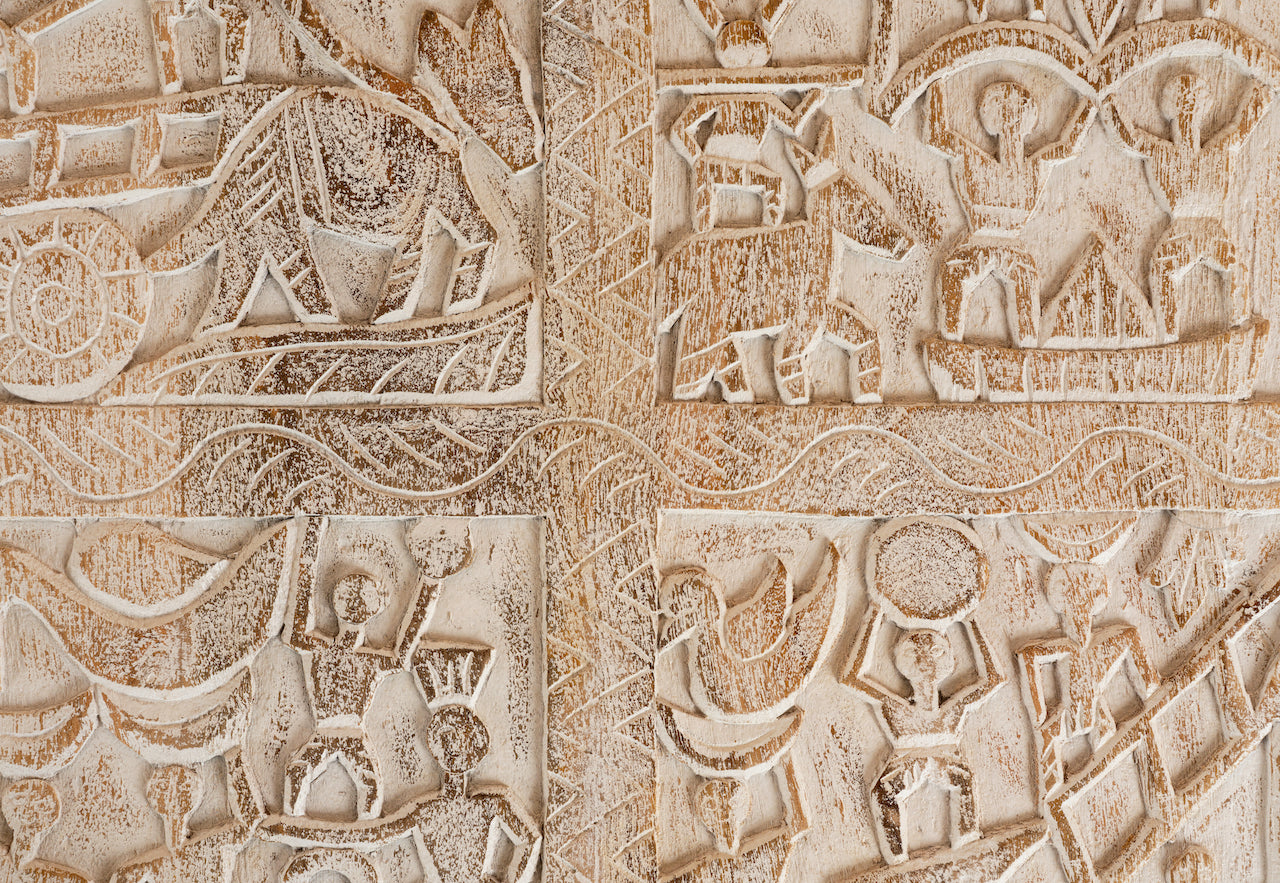 Close up image of a Indian coffee table made from mango wood with Orissa-style carvings and glass top; mango wood coffee table, 90 × 90 × 30 cm.