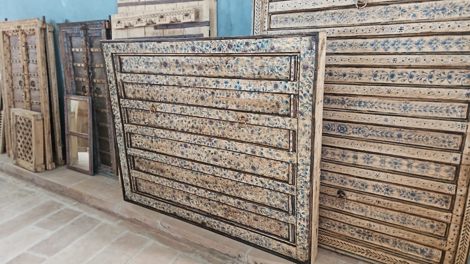 Akshi hand painted head board made from an antique Indian teak door, featuring traditional floral motifs in blue and cream and original iron hardware—an elegant example of hand painted head boards and authentic Indian headboards.