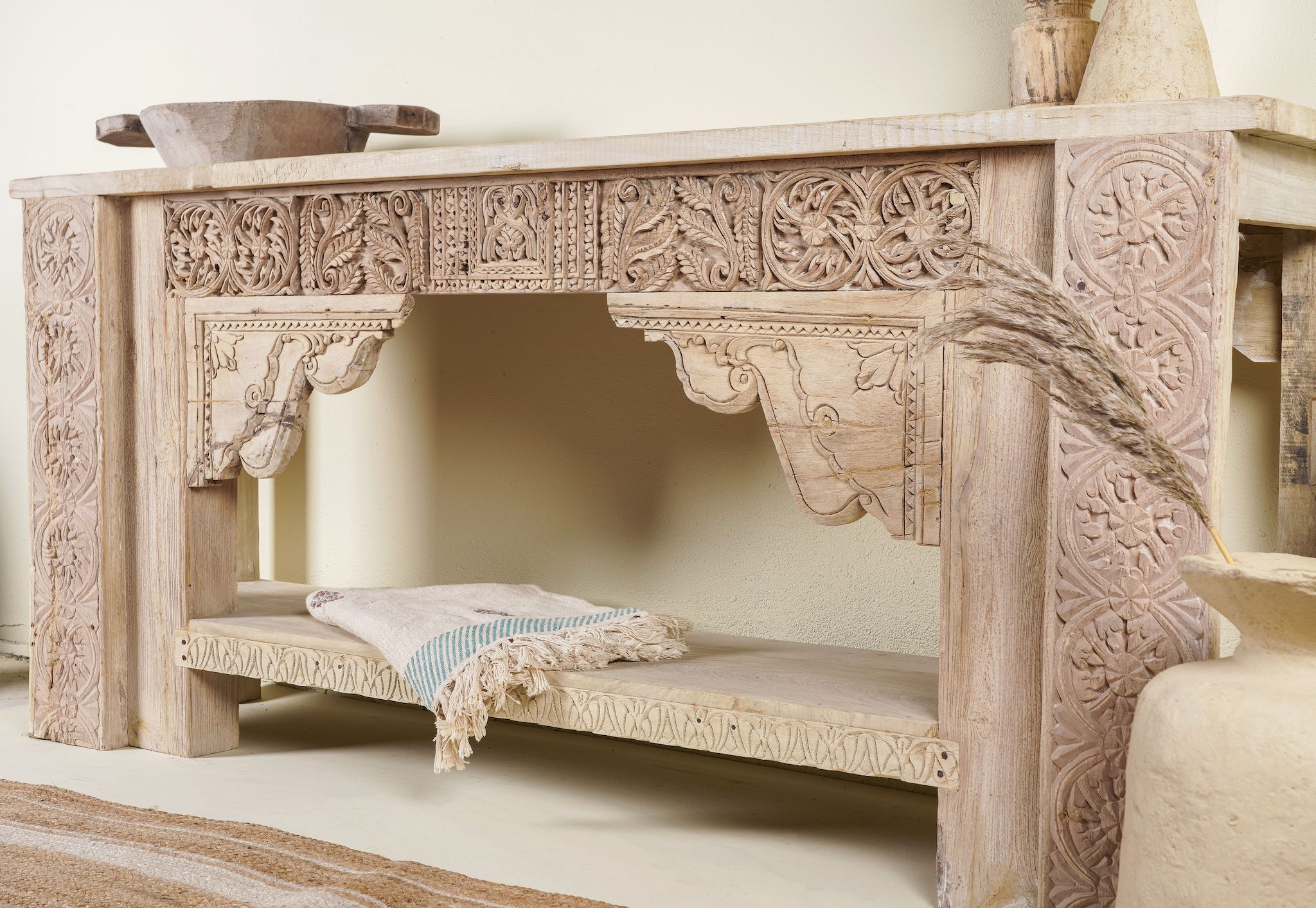 Close up of a antique teak console table made from reclaimed wood with hand-carved floral and geometric panels, 183 × 40 × 82 cm.
