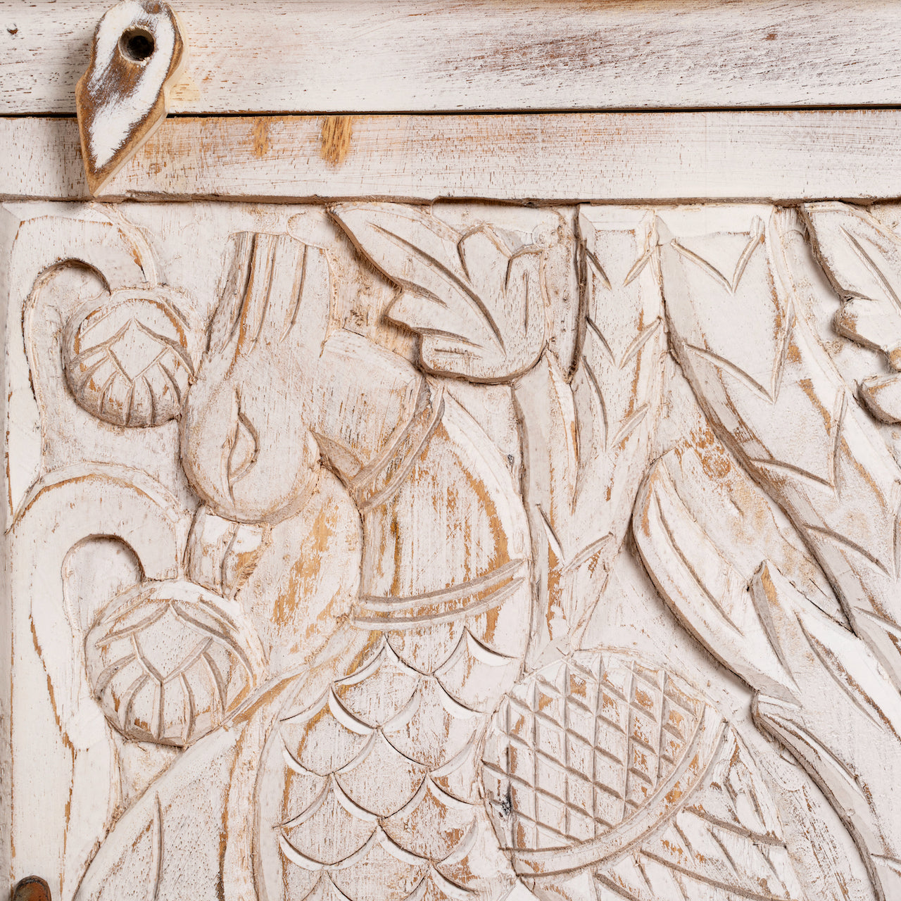 Close up image of a hand-carved mango wood sideboard with peacock and foliage motifs, whitewashed finish; perfect for Indian home decor, 150 × 95 × 40 cm.