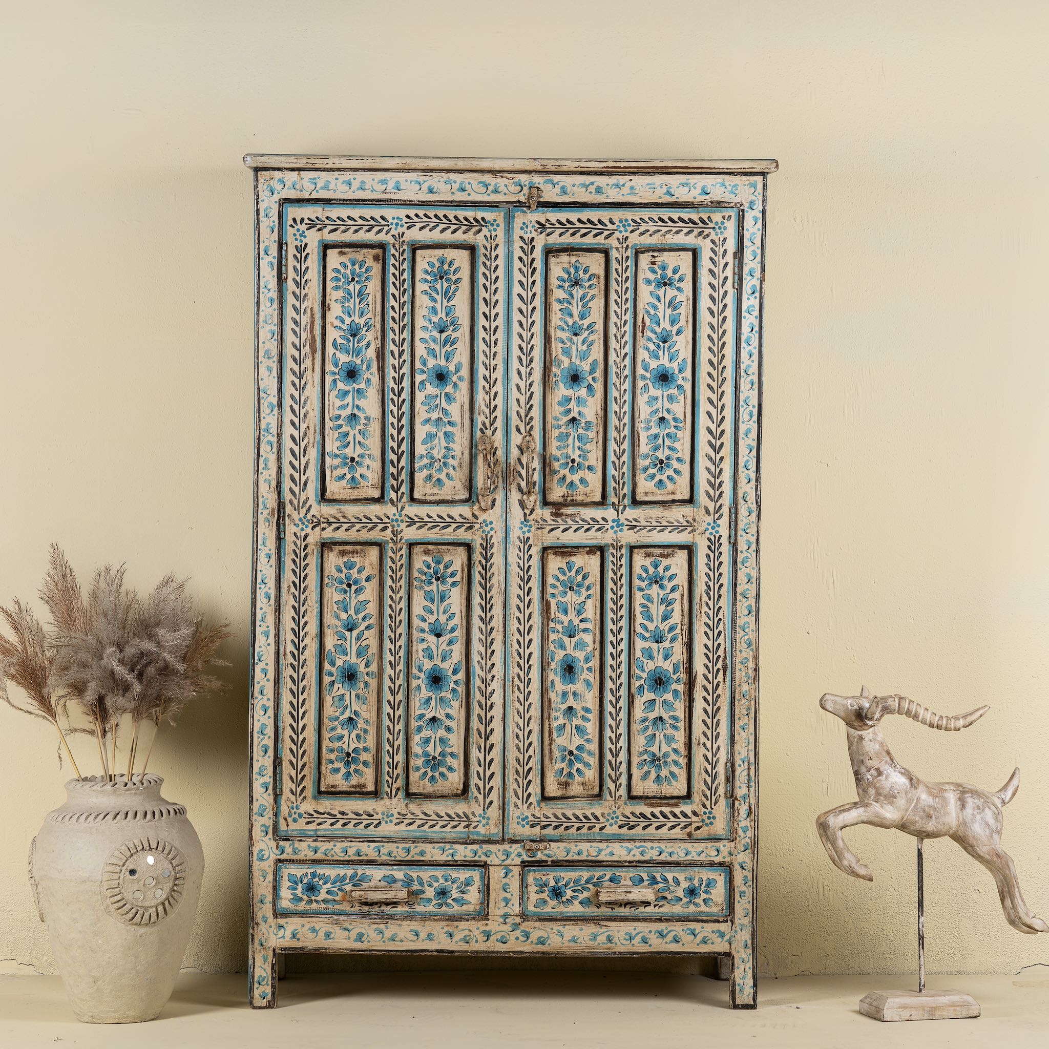 Front view image of a hand painted wooden furniture cabinet with floral motifs, reclaimed teak artisanal furniture in Mediterranean style, 95 × 40 × 152 cm.