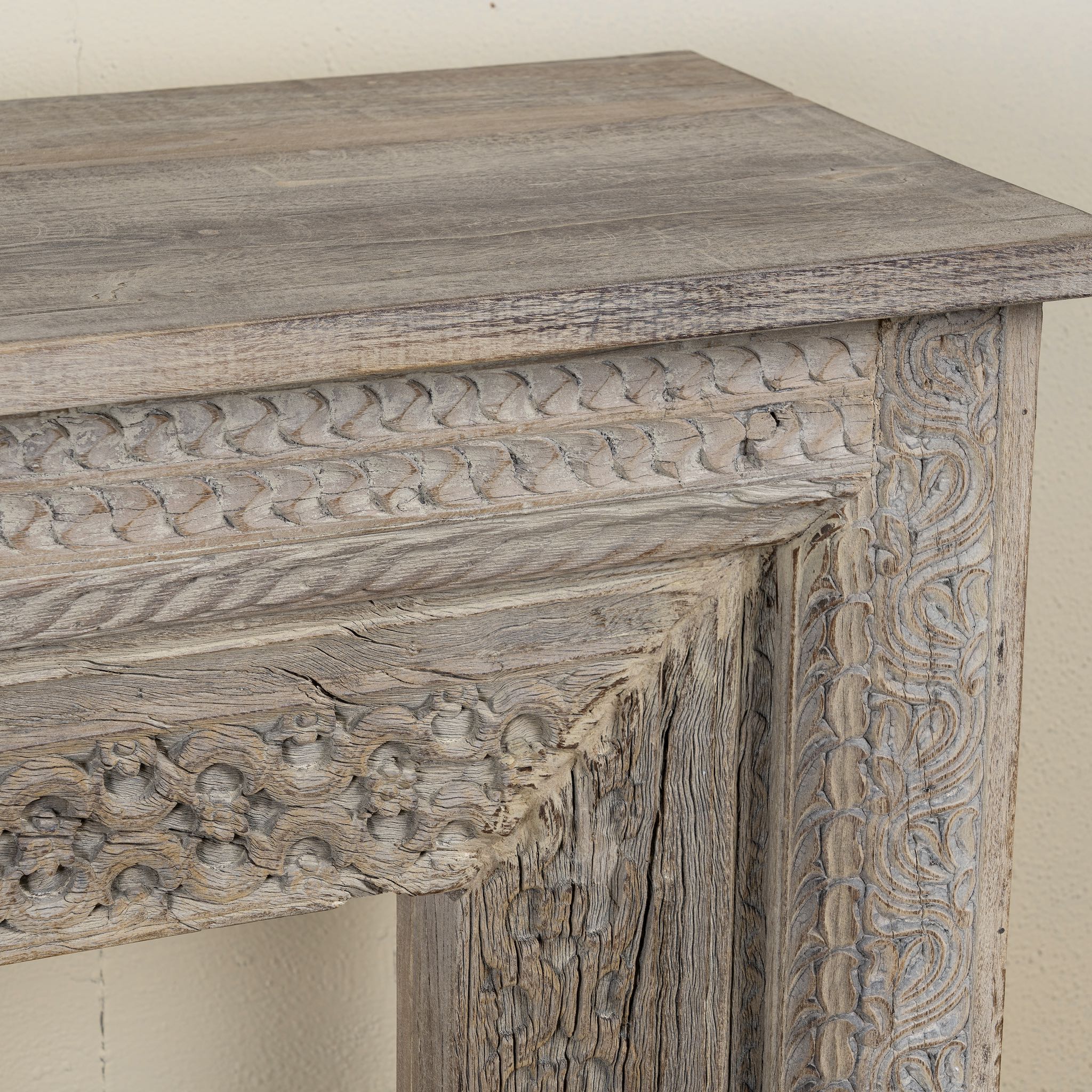 Close up image of a carved console table made from reclaimed teak with antique Indian floral and geometric detailing, 160 × 40 × 90 cm.