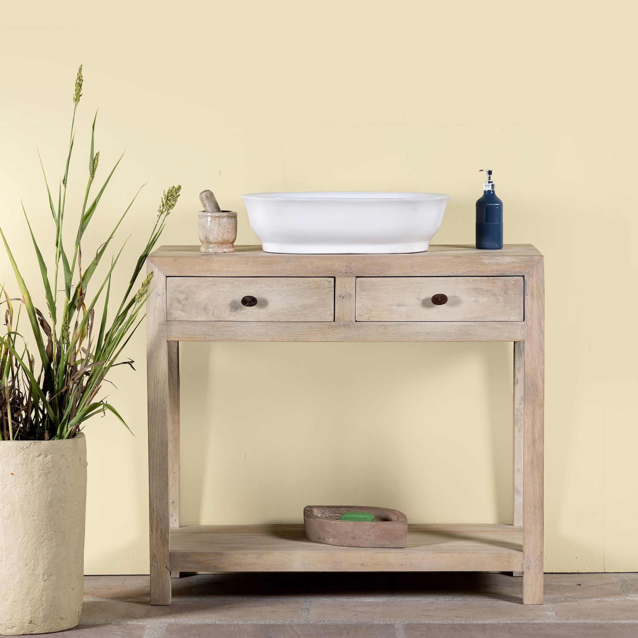 Lifestyle image of a Ibiza style reclaimed wood console table with two drawers and a lower shelf, whitewashed finish, 100 × 40 × 90 cm.