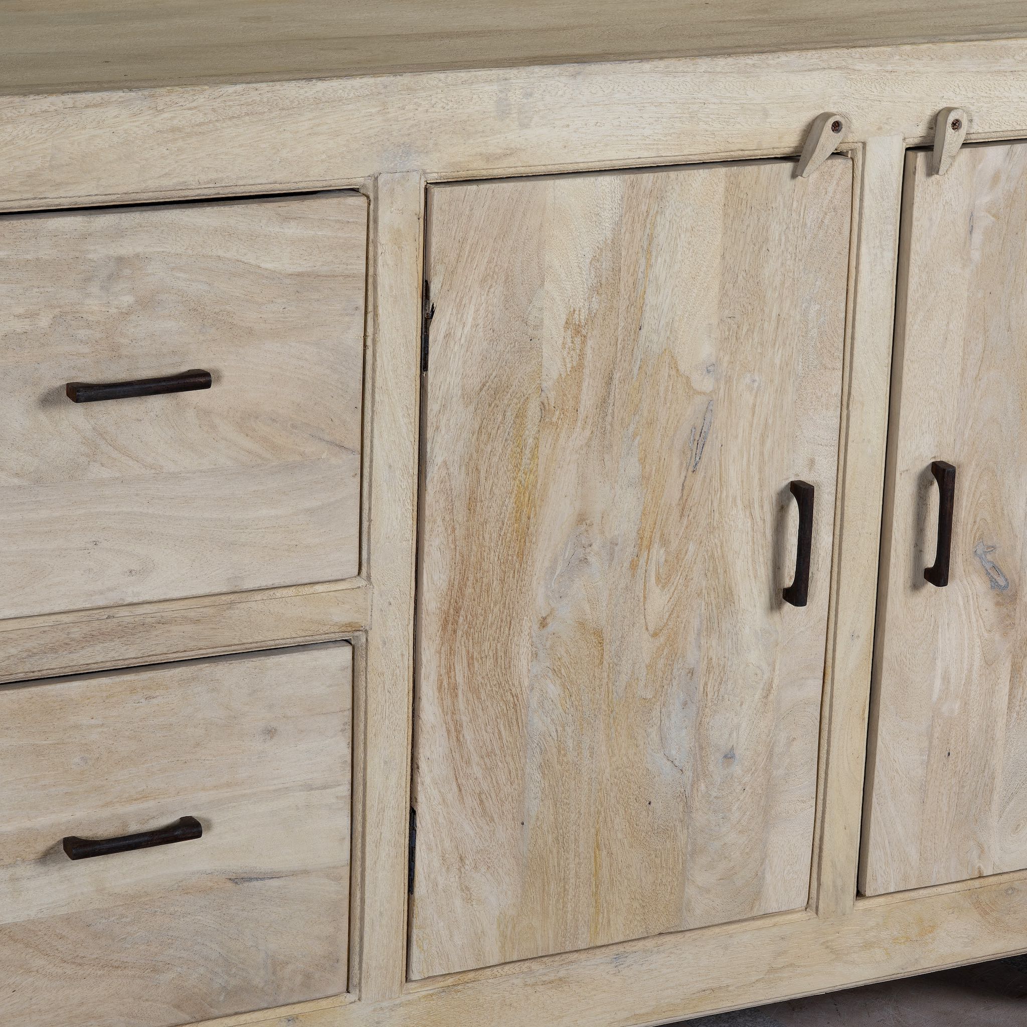 Close up image of a sandblasted wood sideboard with drawers and cabinets, living room furniture in relaxed Ibiza style.
