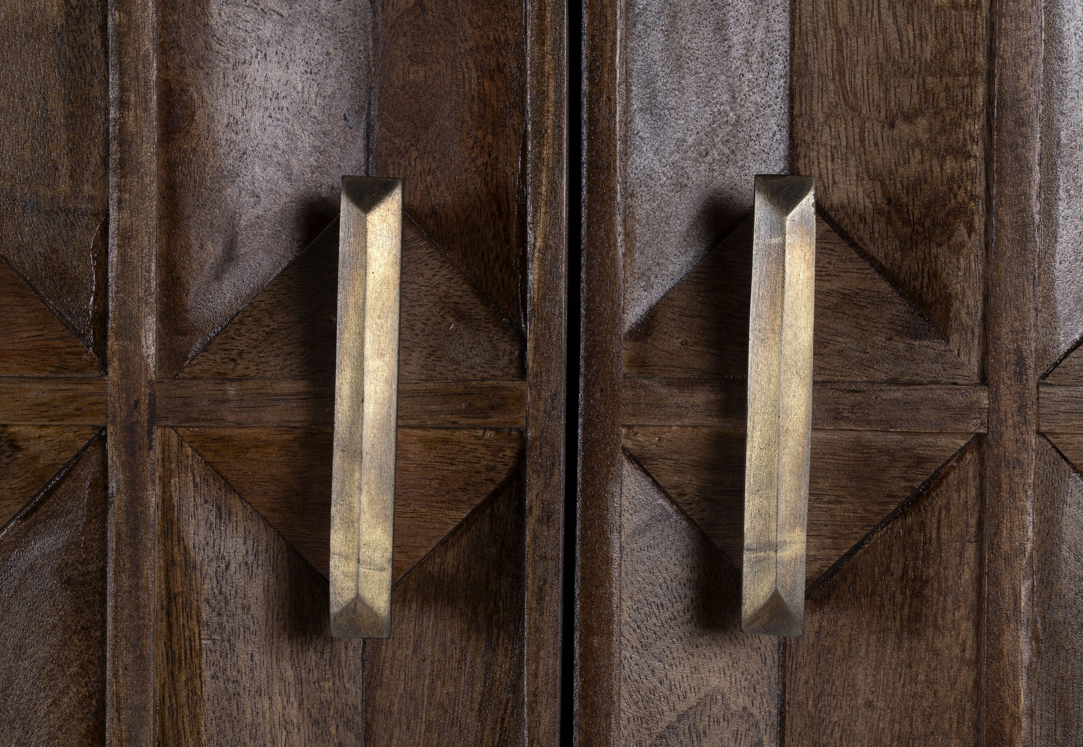 Close up image of a tall mango wood cabinet with diamond tile carving, bronze handles, and black metal base, 86 × 42 × 150 cm.