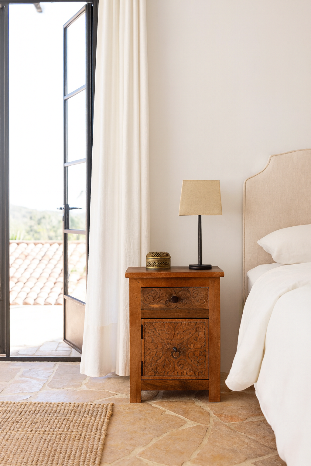 Lifestyle scene with a hand-carved mango wood bedside tables with floral motifs – a set of carved wooden furniture perfect for rustic and relaxed interiors.