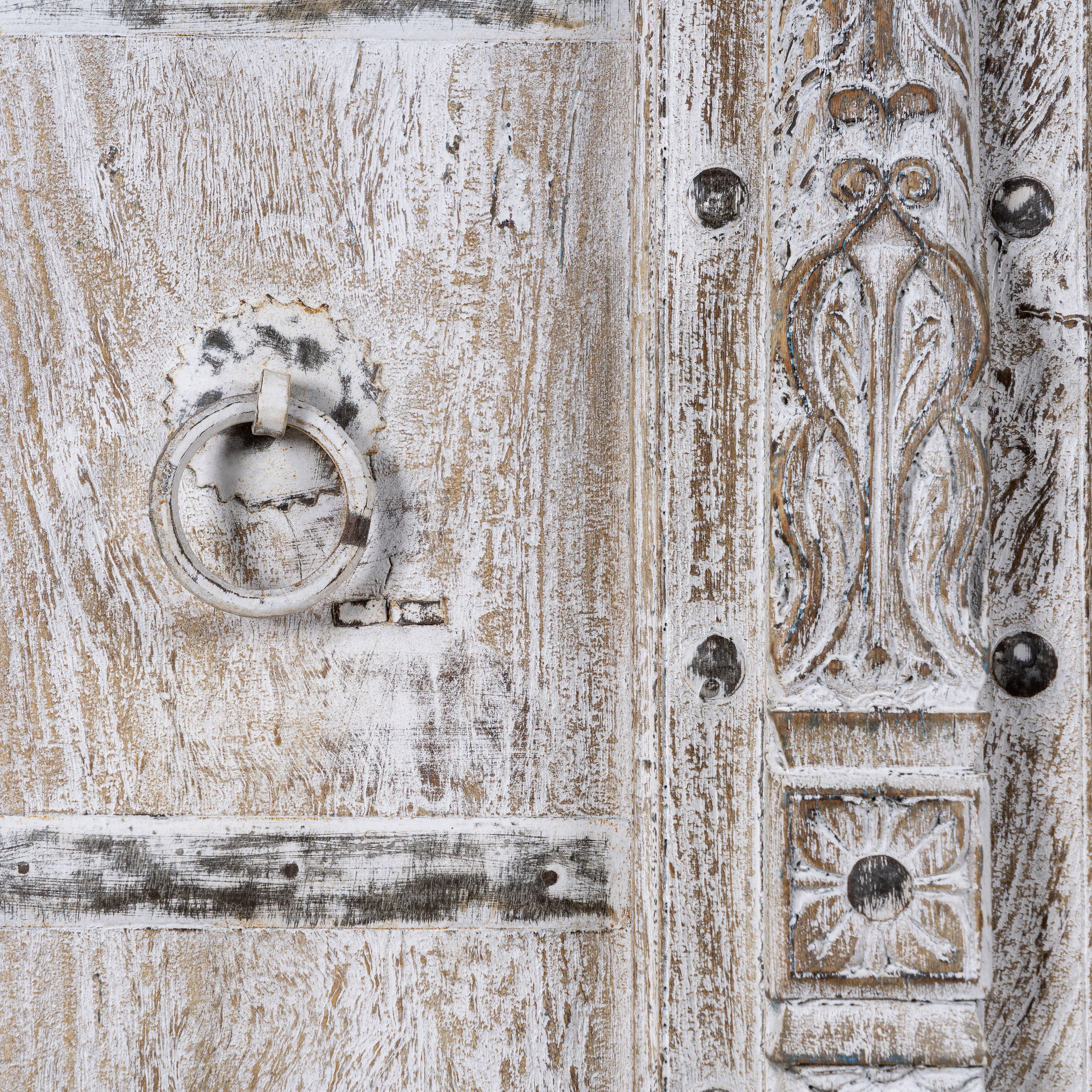 Close up image of a handcrafted cabinet with reclaimed Indian window frame doors, white-washed finish, and iron accents – vintage home decor with teak furniture appeal.