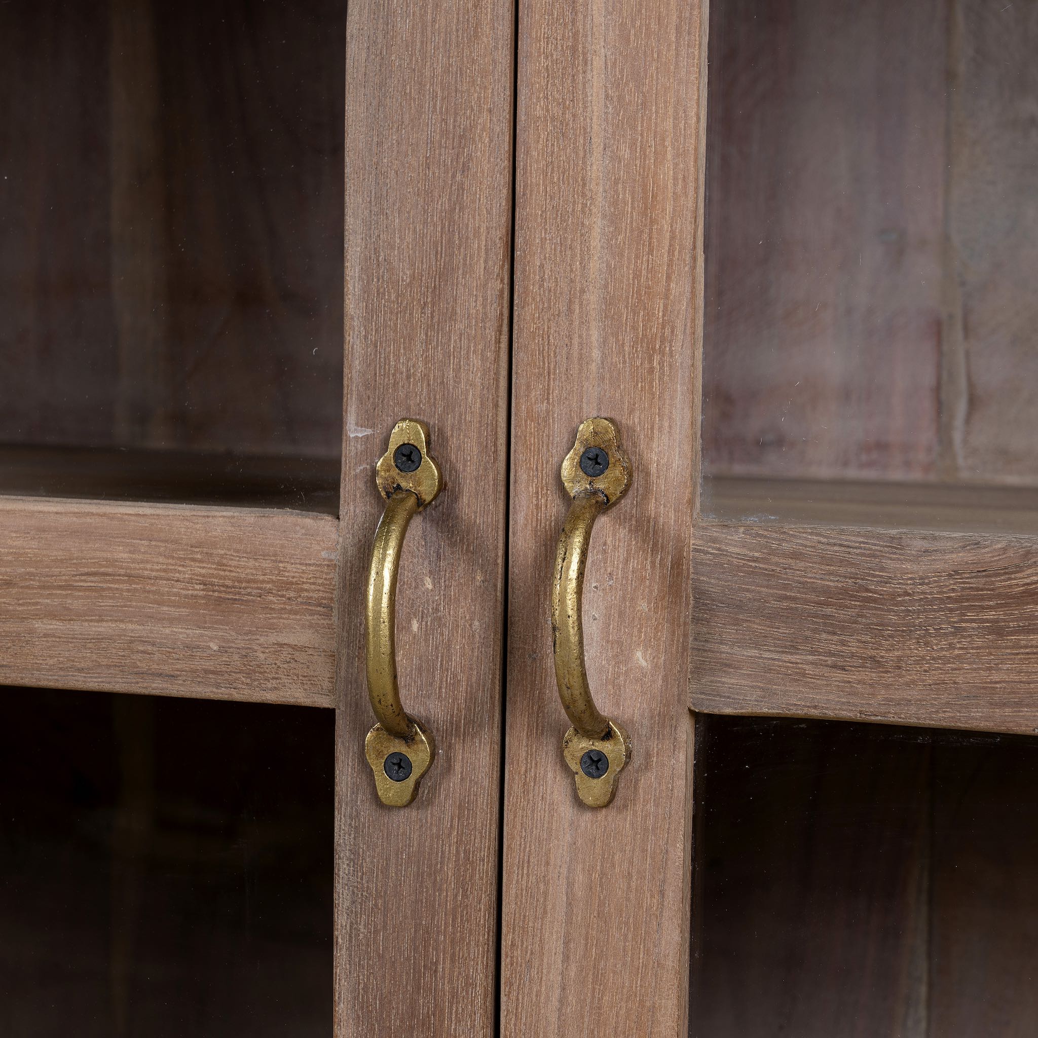 Close up image of the handles of a reclaimed wood dresser with four glass doors, teak wood showcase cabinet with brass handles and wooden latches, 170 × 40 × 90 cm.