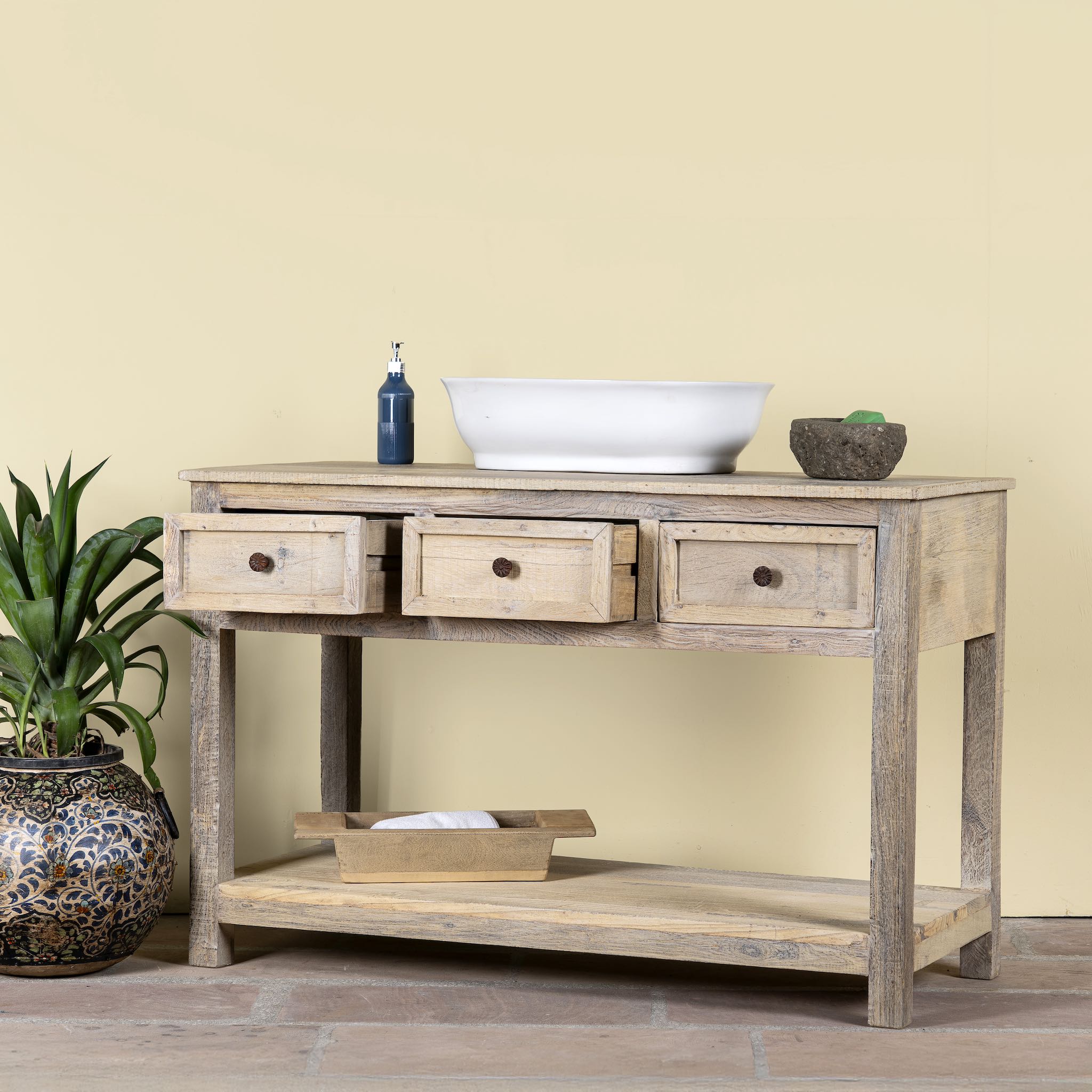 Side angle with open drawers of a sandblasted reclaimed wood bathroom console table with 3 drawers and open shelf; sustainable furniture, 120 × 50 × 80 cm.