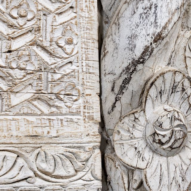 Close up image of a white-washed carved console table made from reclaimed wood with floral detailing; Mediterranean and Ibiza style furniture, 160 × 80 × 48 cm.