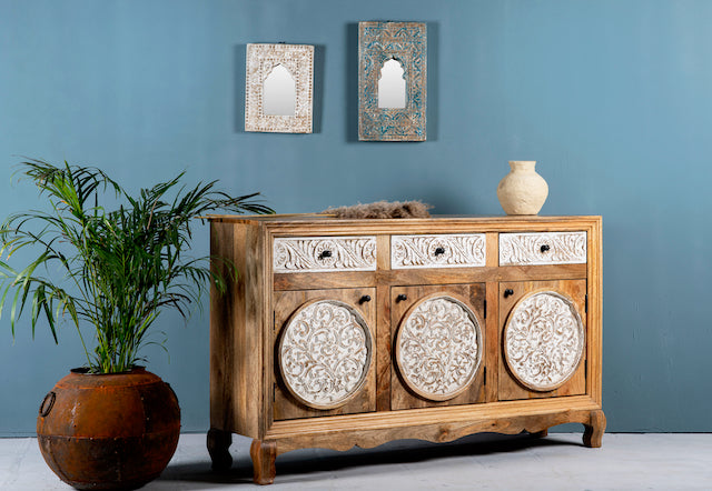 Sde angle image of a hand carved wooden sideboard made from mango wood with floral carvings and curved base, mango wood furniture with storage, 150 × 40 × 95 cm.