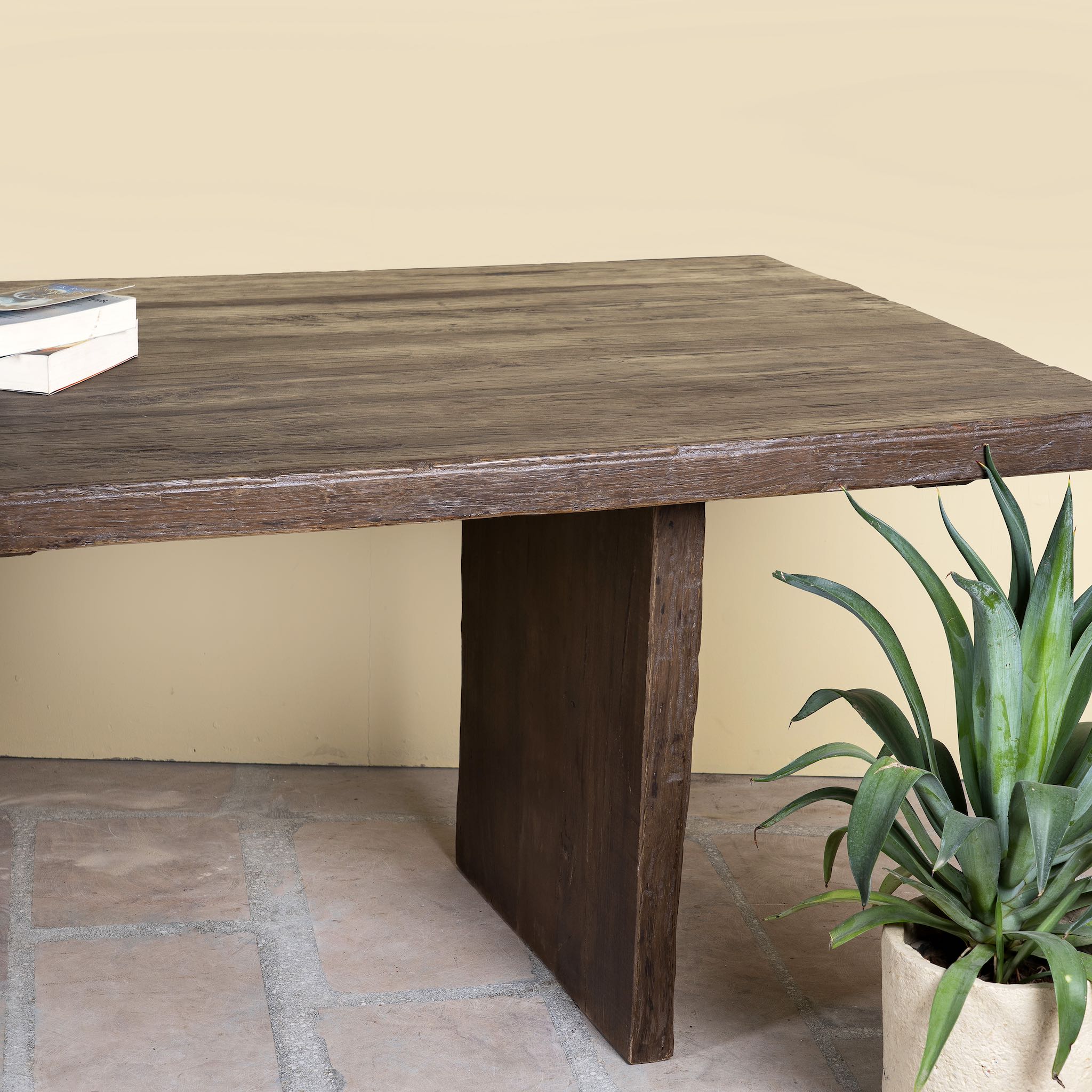 Close up image of a rustic reclaimed wood log dining table with block legs, sustainable furniture design, 240×100×75 cm.