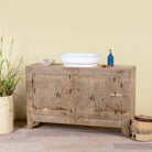 Side angle image of a Reclaimed wood sideboard made from antique teak doors with carved detailing; teak furniture, 134 × 37 × 82 cm.