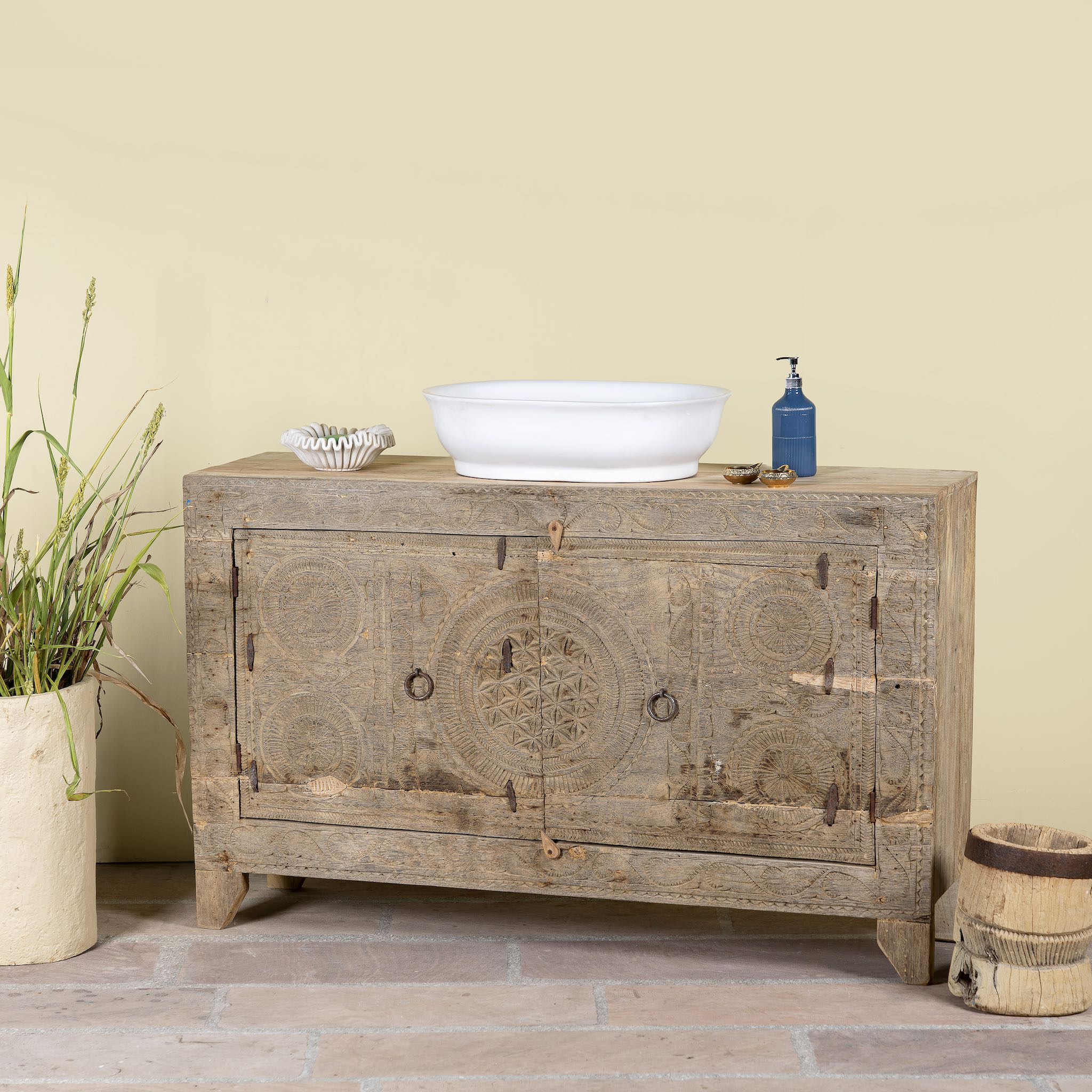 Side angle image of a Reclaimed wood sideboard made from antique teak doors with carved detailing; teak furniture, 134 × 37 × 82 cm.