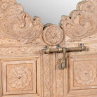 Close up image of a handcarved teak wood mirror made from an antique Indian window frame with brass lock; unique wooden furniture, 60 × 70 cm.