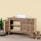 Side angle image with open door of Etasha, a reclaimed wood sideboard made from antique teak doors with carved detailing; teak furniture, 130 × 38 × 83 cm.