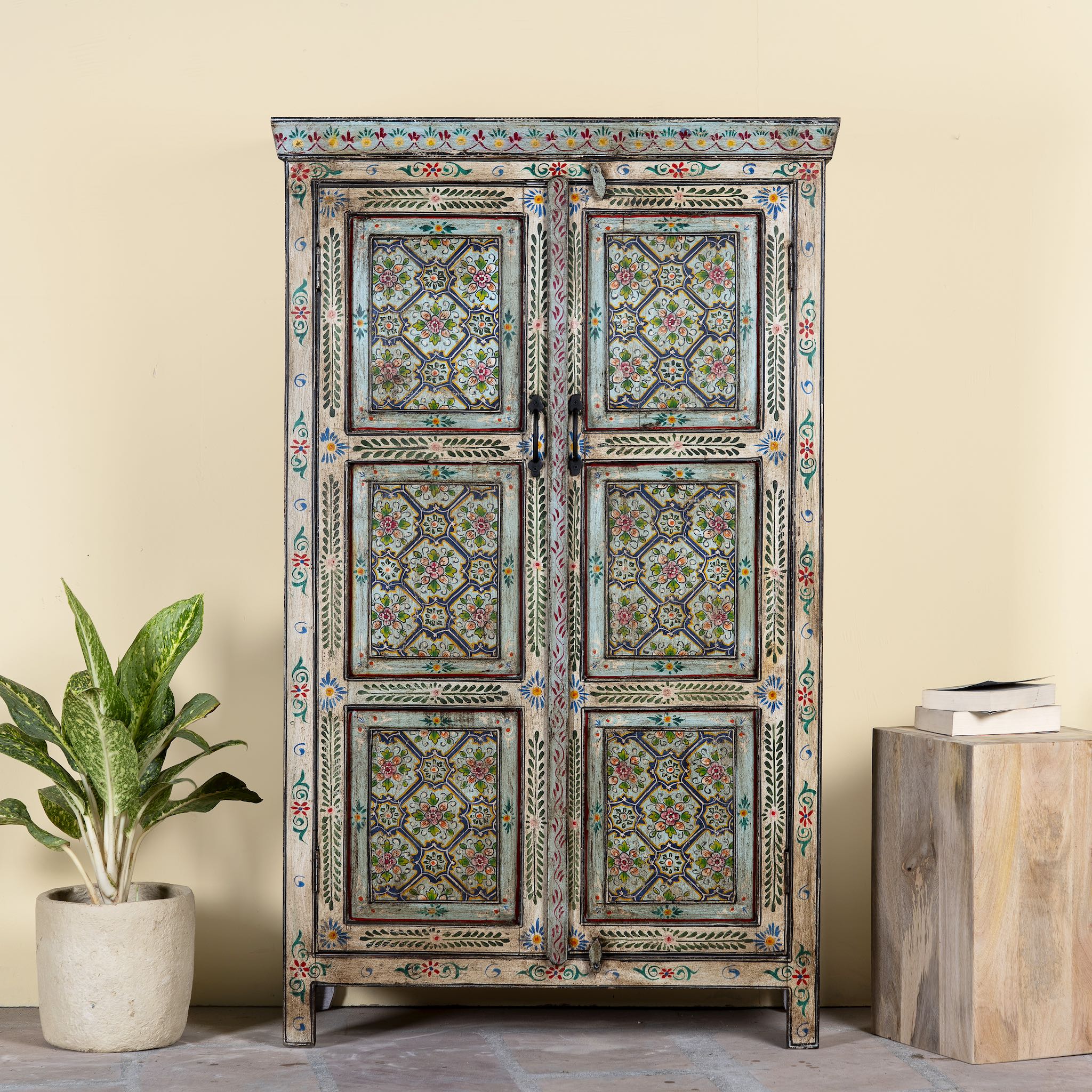 Reclaimed wood cabinet with floral and geometric designs, perfect for a bohemian interior with Mediterranean style.