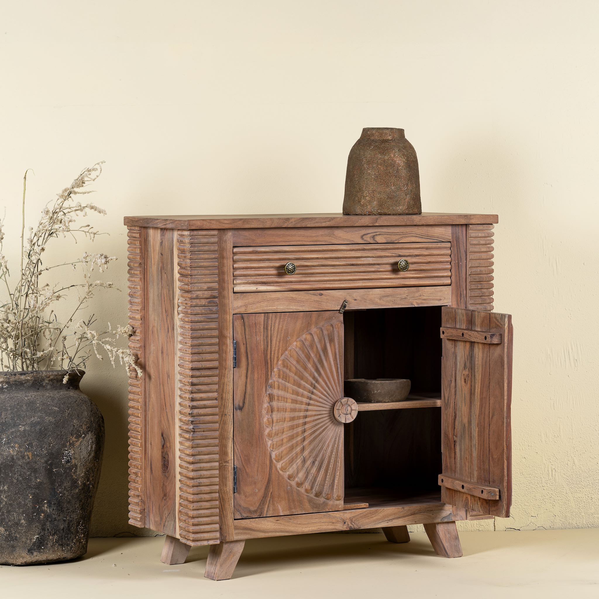 Open Door image of a acacia wood cabinet with hand-carved sunburst doors, grooved details, and one drawer, 90 × 40 × 90 cm.
