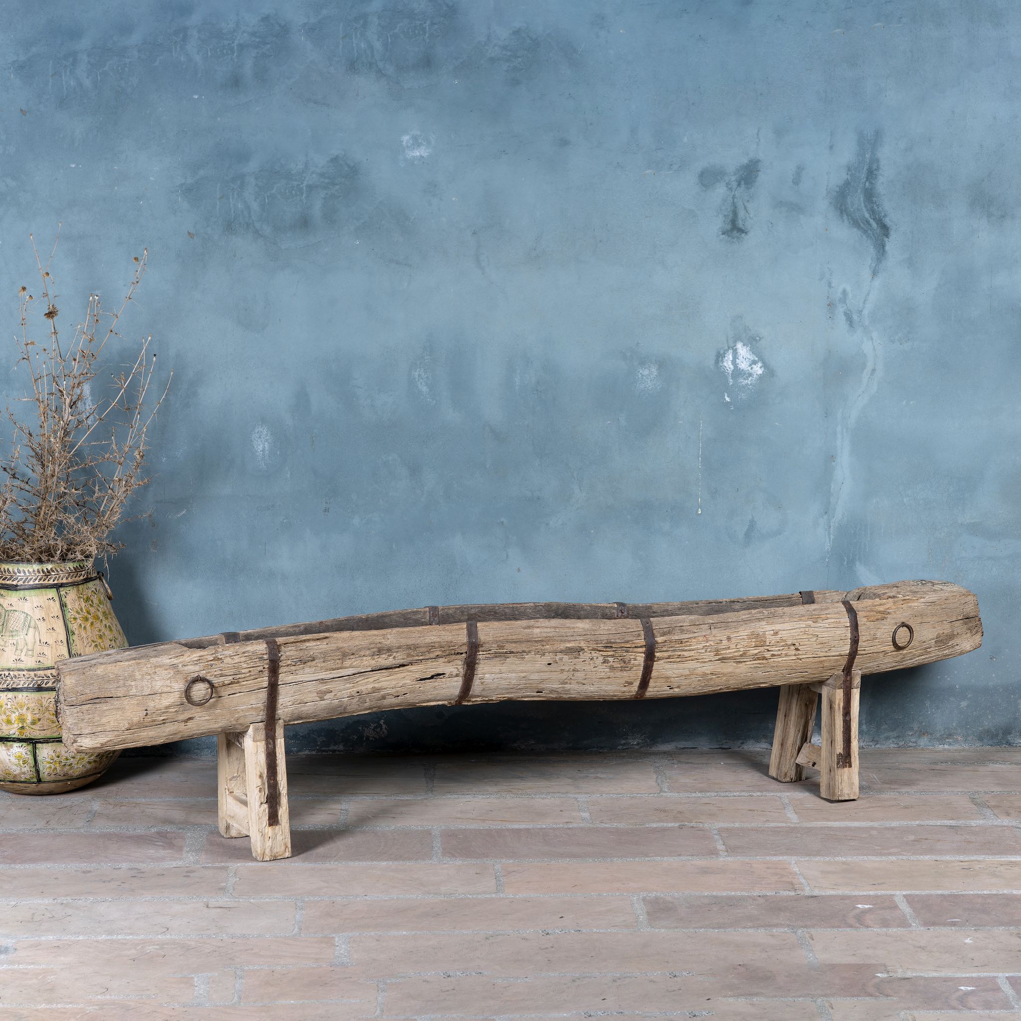 Antique console table repurposed from reclaimed teak wood feeding trough with carved details and iron fittings; unique furniture ideal for rustic interiors, compatible with teak wood benches, 234 × 31 × 61 cm.