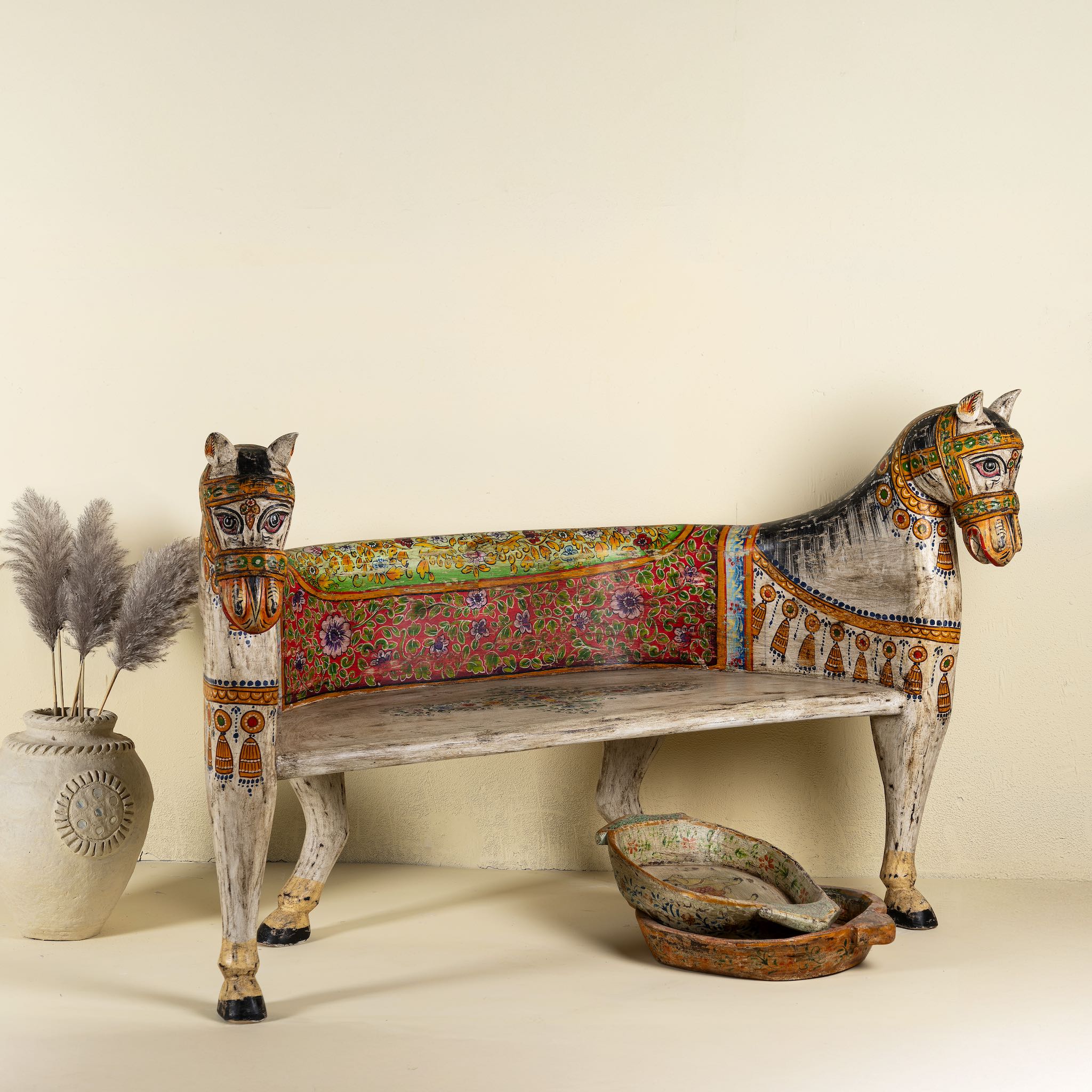 Side angle image of a hand-painted reclaimed wood chair-style horse bench with double carvings; unique furniture for a bohemian interior, 160 × 70 × 90 cm.