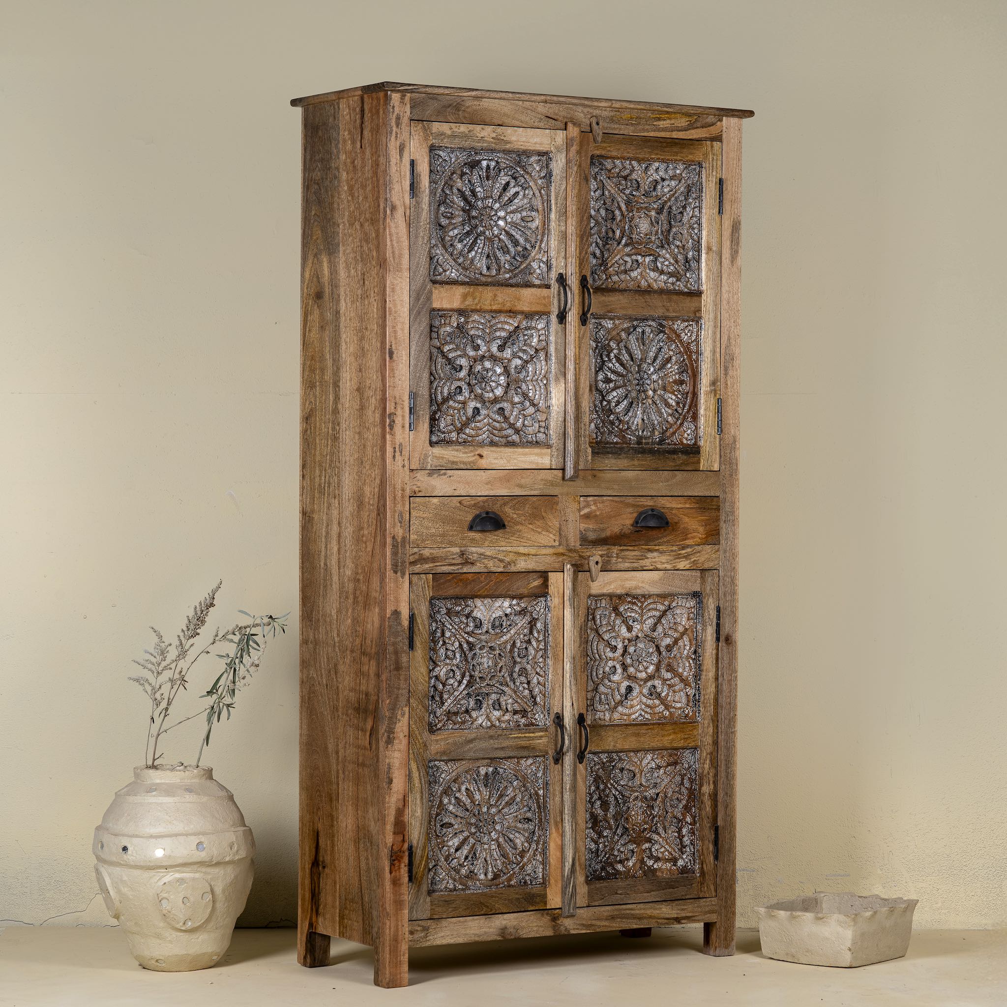Side view of a hand-carved mango wood cabinet with floral motifs and silver finish – bedroom furniture with rustic charm and artisanal detail.
