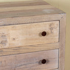 Close up image of a reclaimed wood chest of 3 drawers with rustic finish and round knobs; Ibiza style sustainable furniture, 90 × 50 × 80 cm.