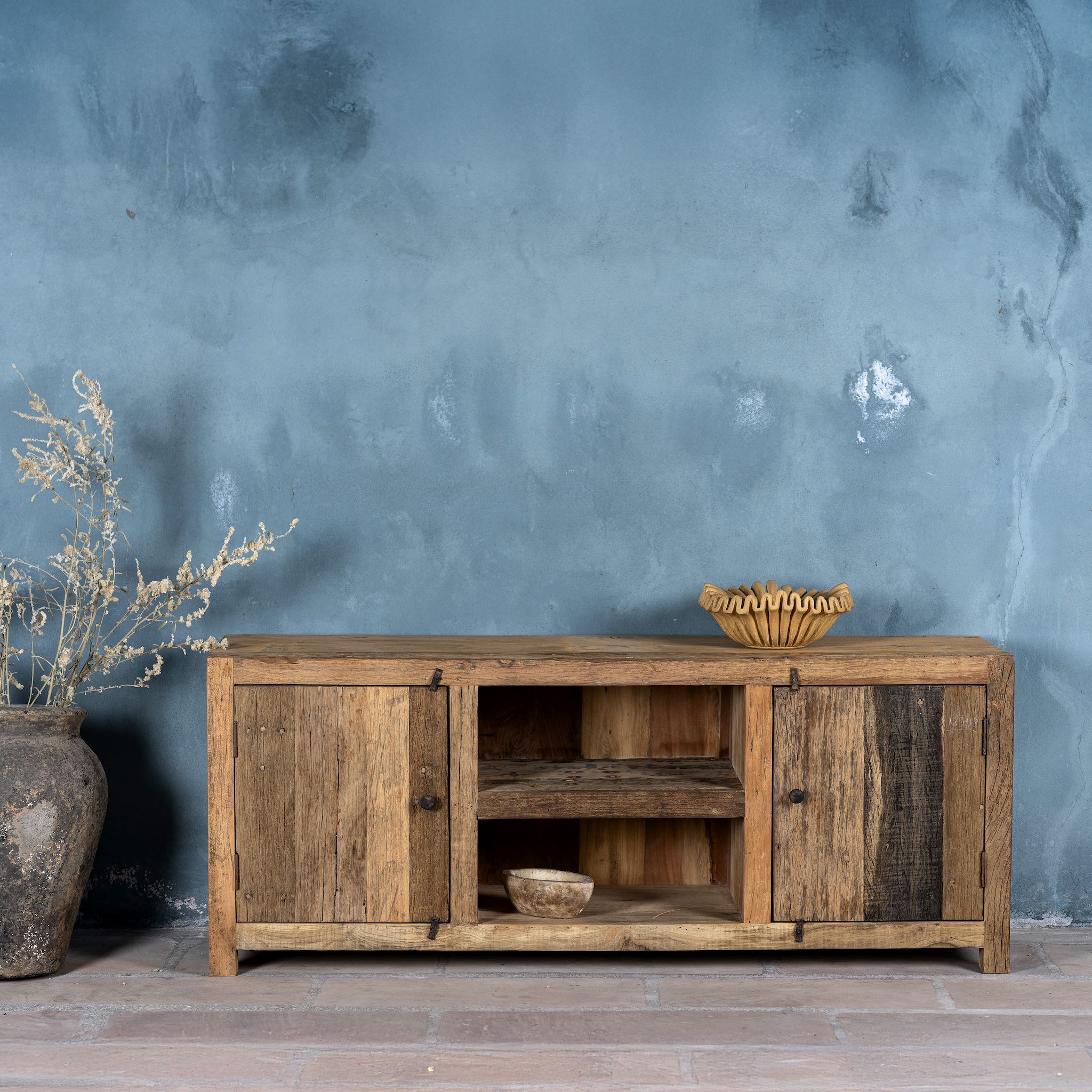Front view of a driftwood lowboard made from reclaimed wood with two cabinets, open shelving, and rustic minimalist design, 150 × 40 × 60 cm.
