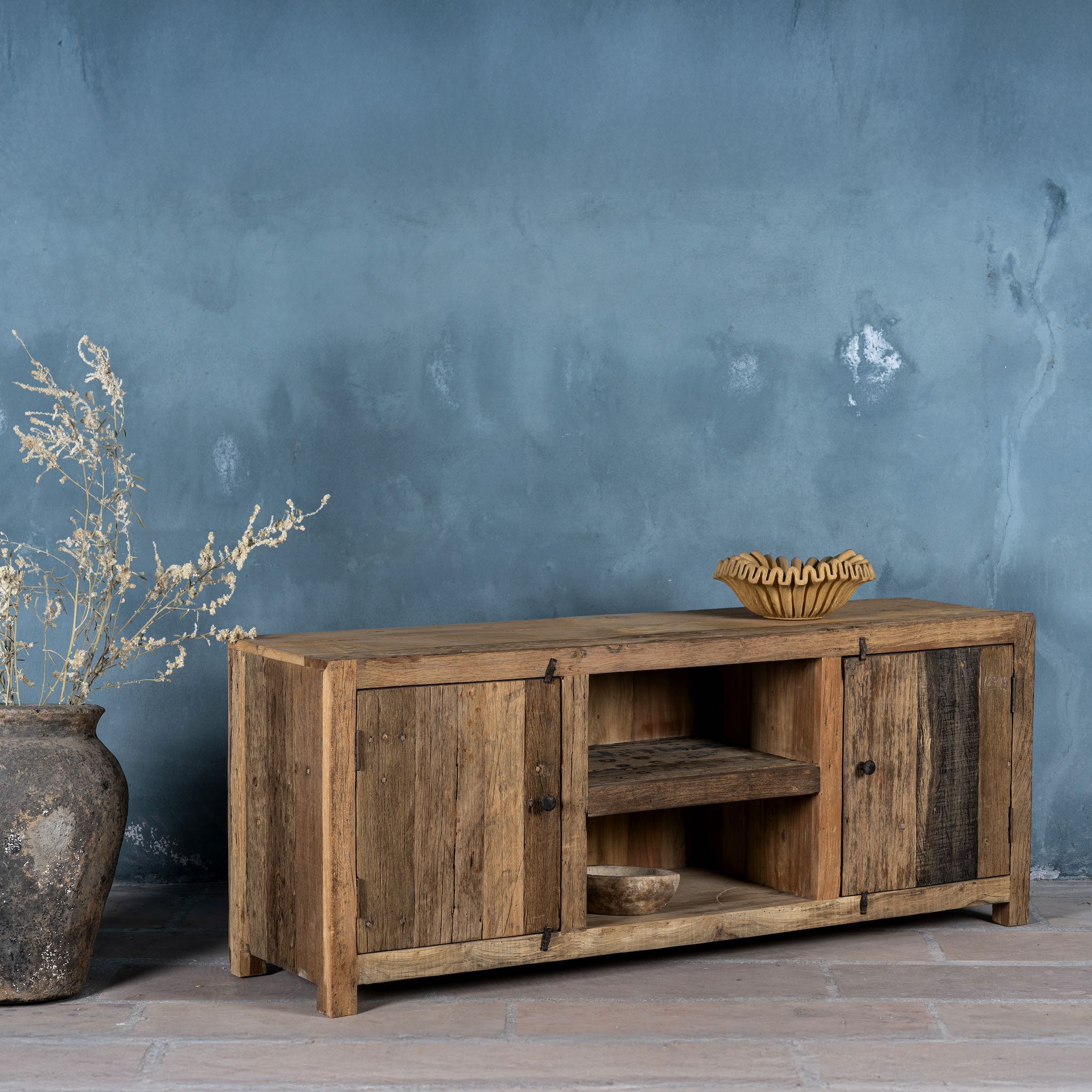 Side view image of a driftwood lowboard made from reclaimed wood with two cabinets, open shelving, and rustic minimalist design, 150 × 40 × 60 cm.