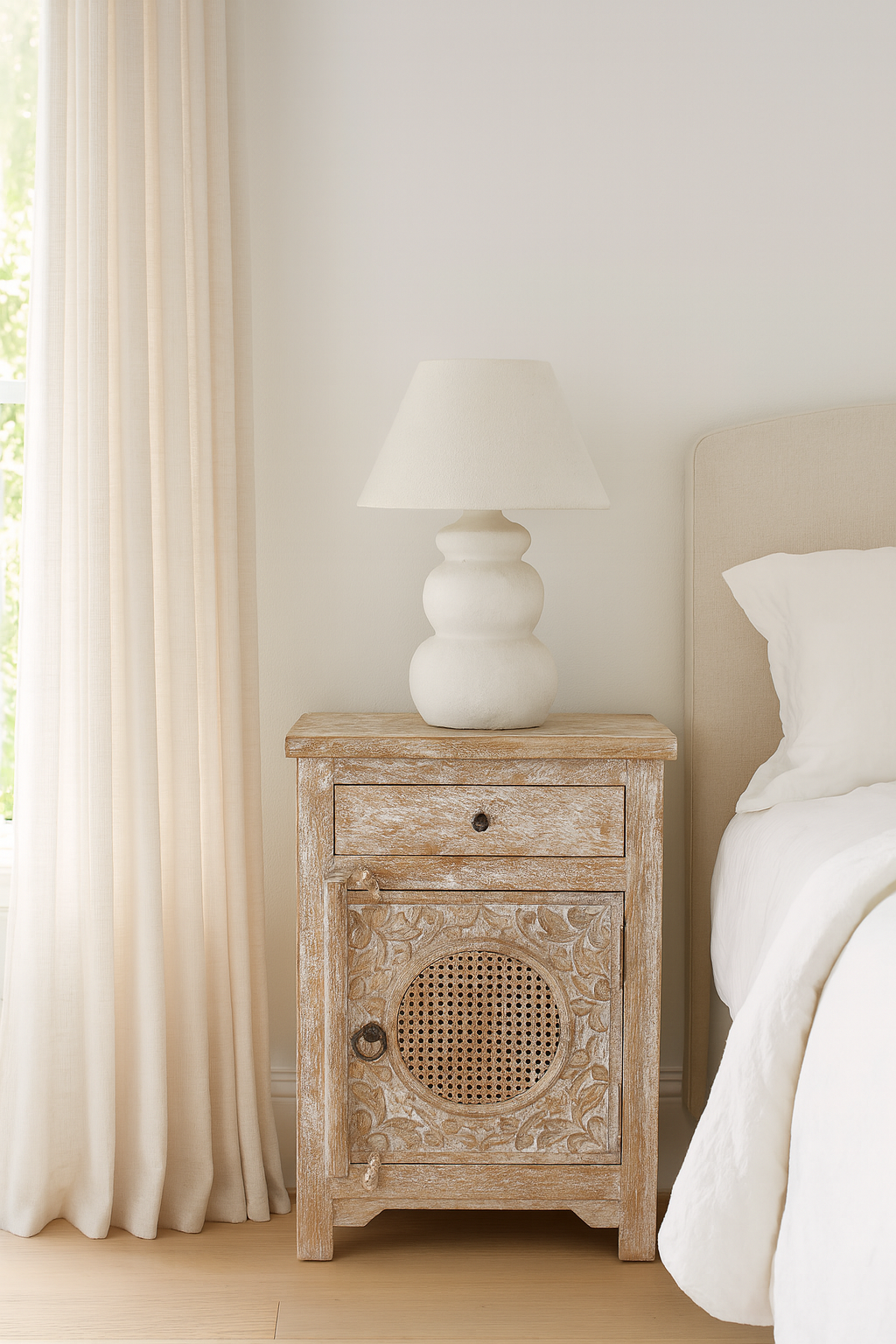 Lifestyle inspiration of a hand carved mango wood night stand with rattan inserts; sustainable bedroom furniture, 67 × 47 × 40 cm.