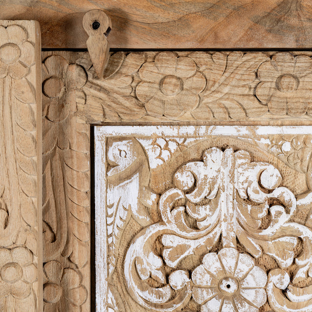 Close up image of a hand carved wooden wardrobe made of solid mango wood with whitewashed floral details; Ibiza-style mango wood wardrobe, 190 × 100 × 40 cm.
