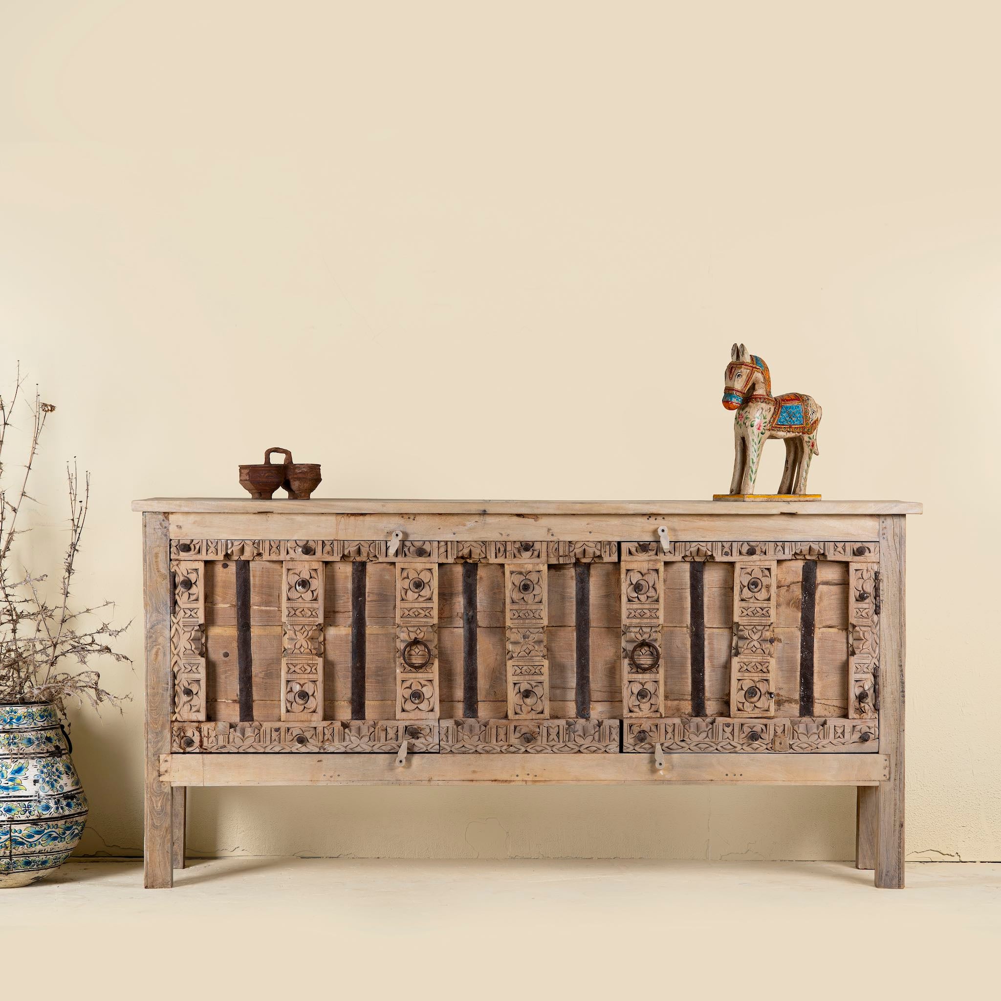 Console table made from old teak door panels, featuring traditional hand-carved details, iron ring accents, and built-in storage in a natural rustic finish.