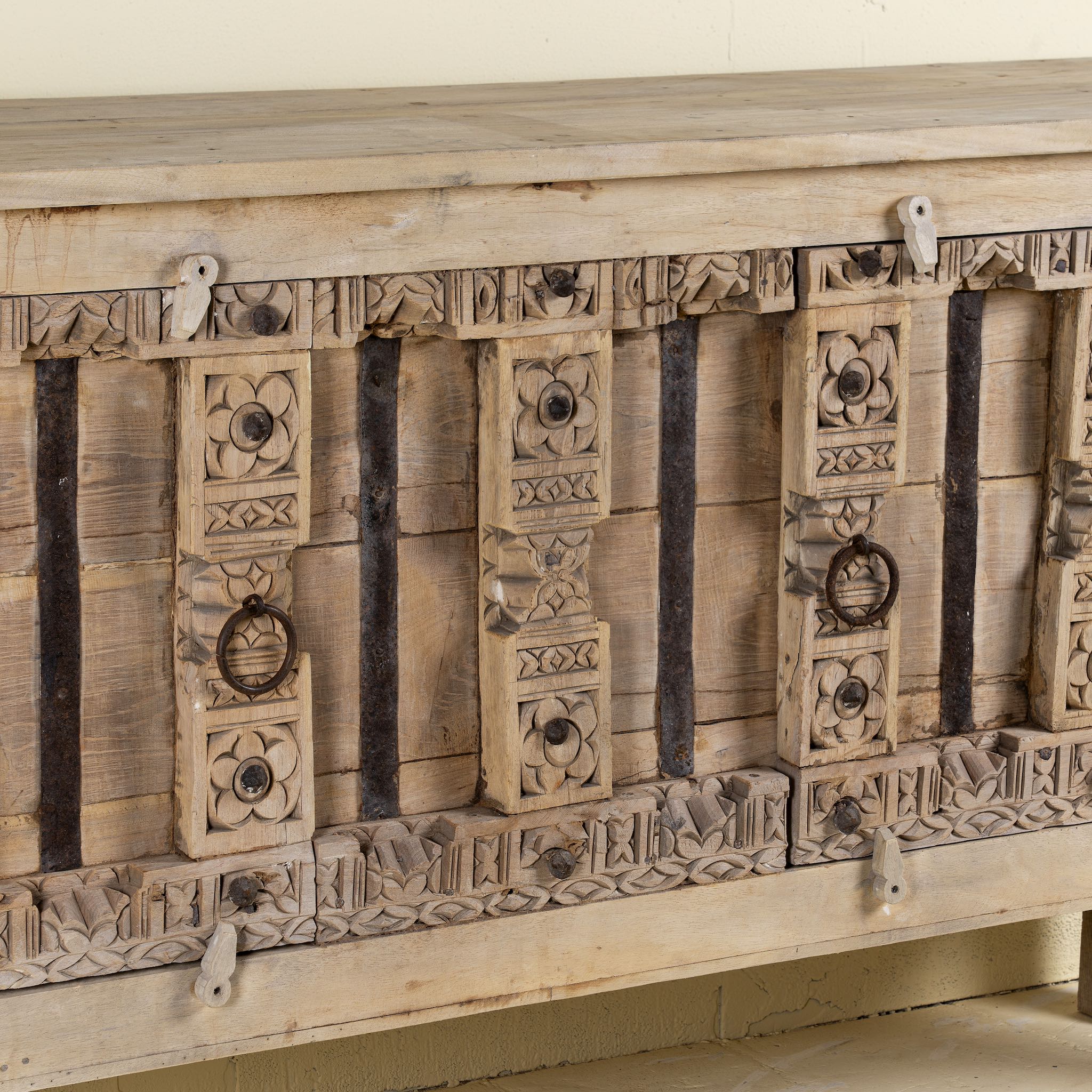 Wooden cabinet with intricate carvings on a light background
