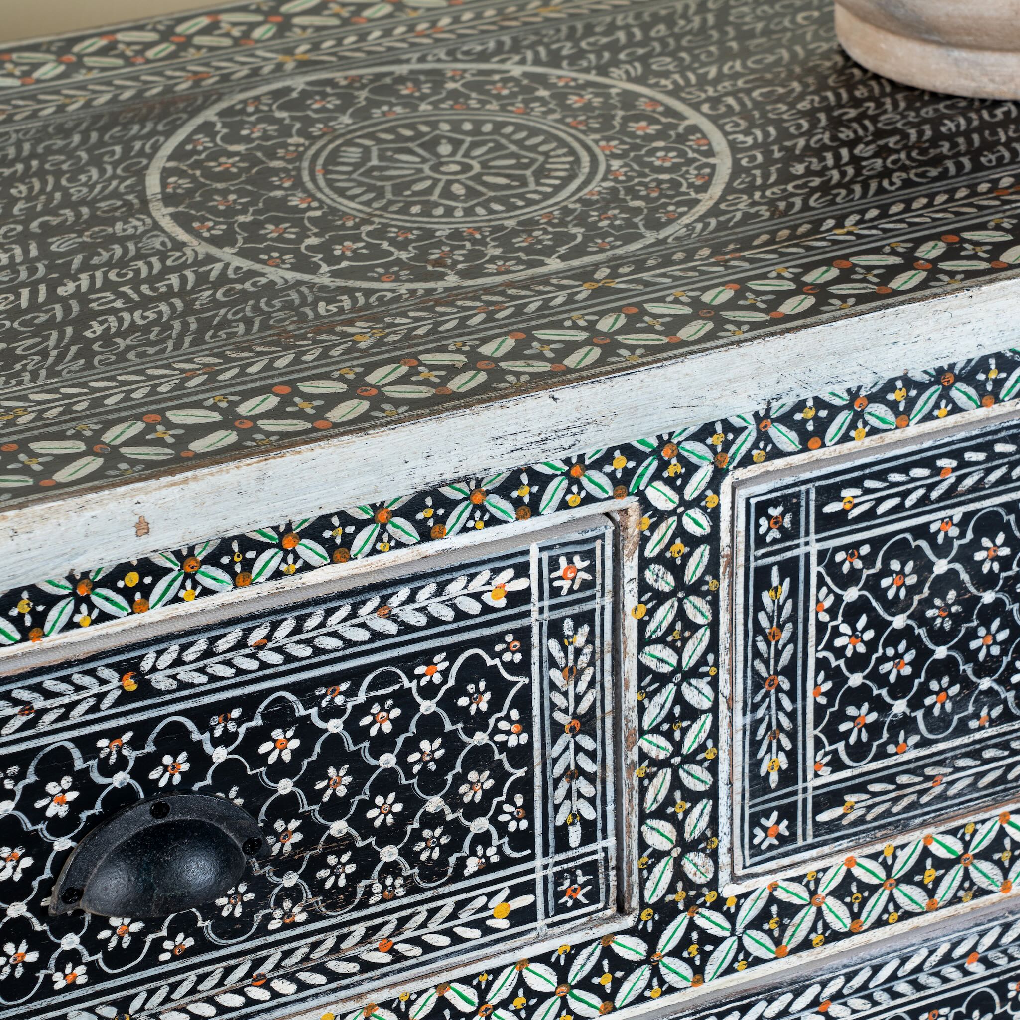 Close up image of a of a hand-painted Indian chest of drawers made from recycled wood – unique furniture featuring colourful motifs and antique craftsmanship.