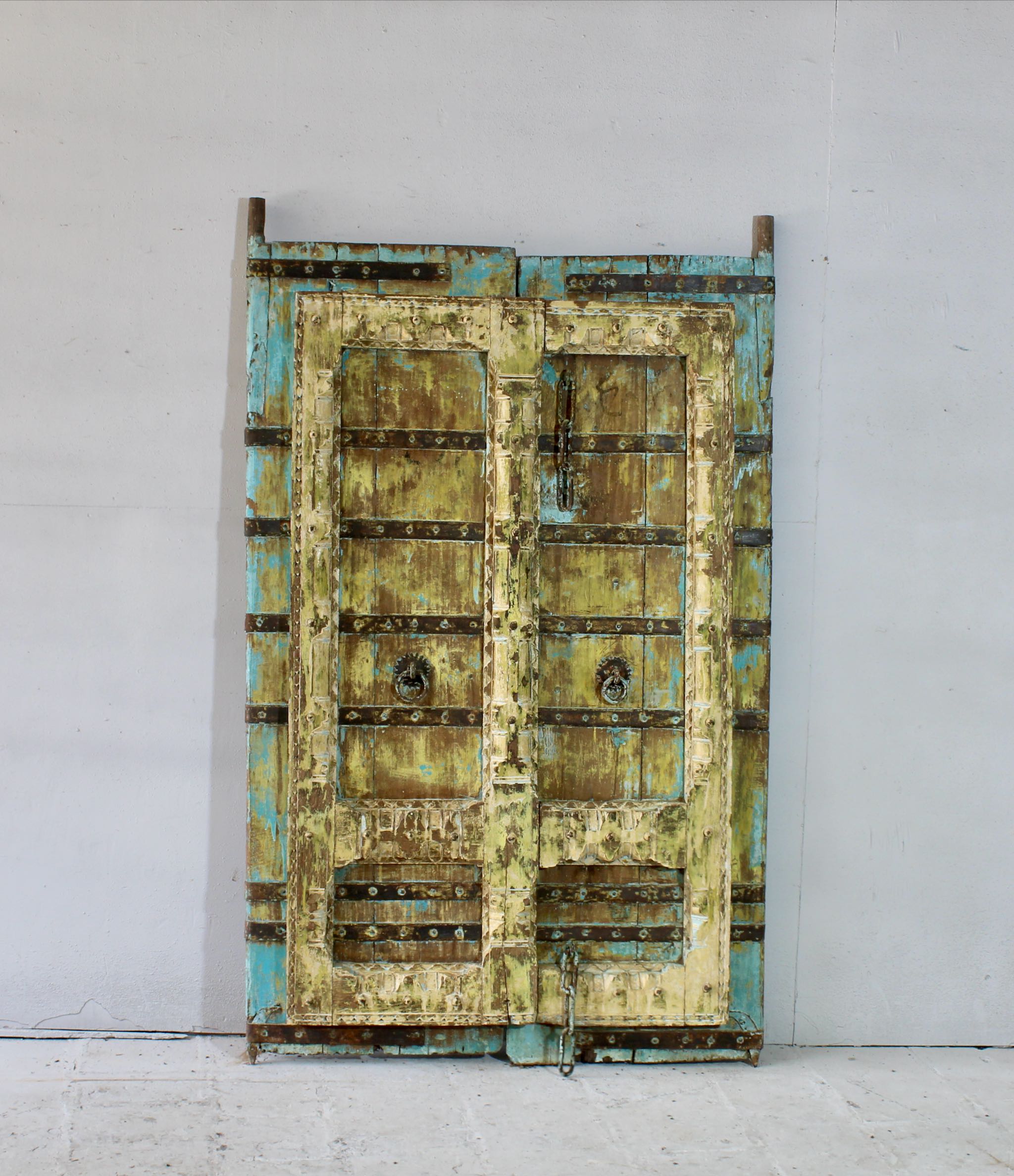Antique Indian teak and iron door with distressed turquoise and ochre patina, rustic vintage wall panels and bold vintage home decor.