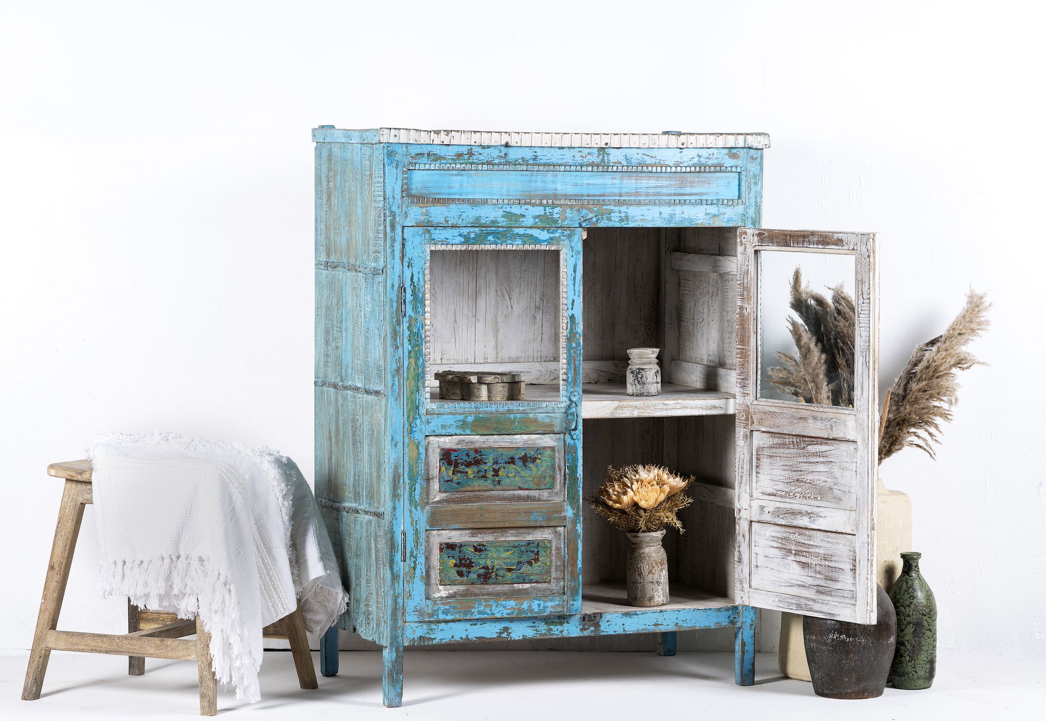 Open door view of a blue vintage glass door cabinet made of reclaimed wood with added decoration.