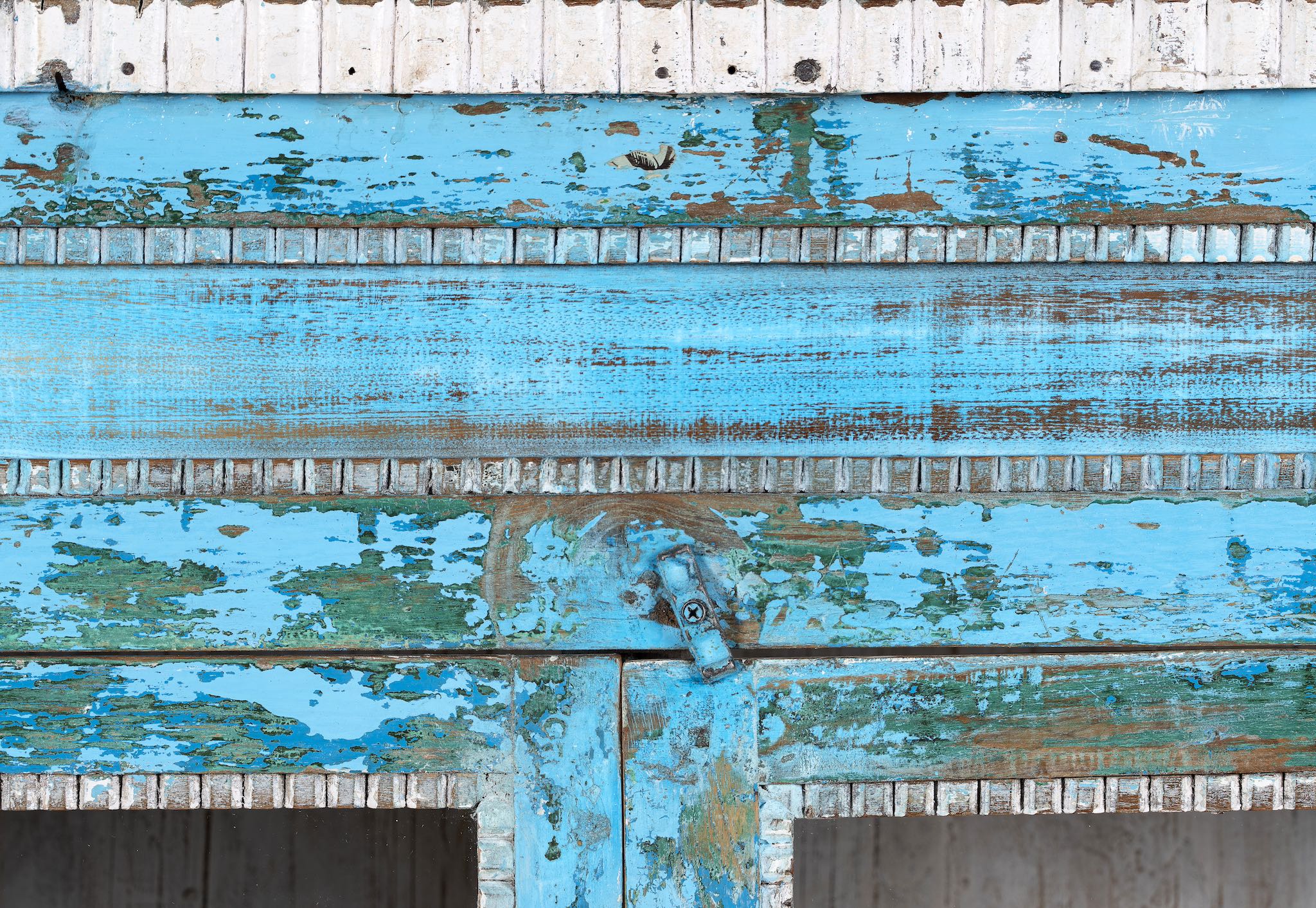 Close up Picture of a blue vintage glass door cabinet made of reclaimed wood with added decoration.