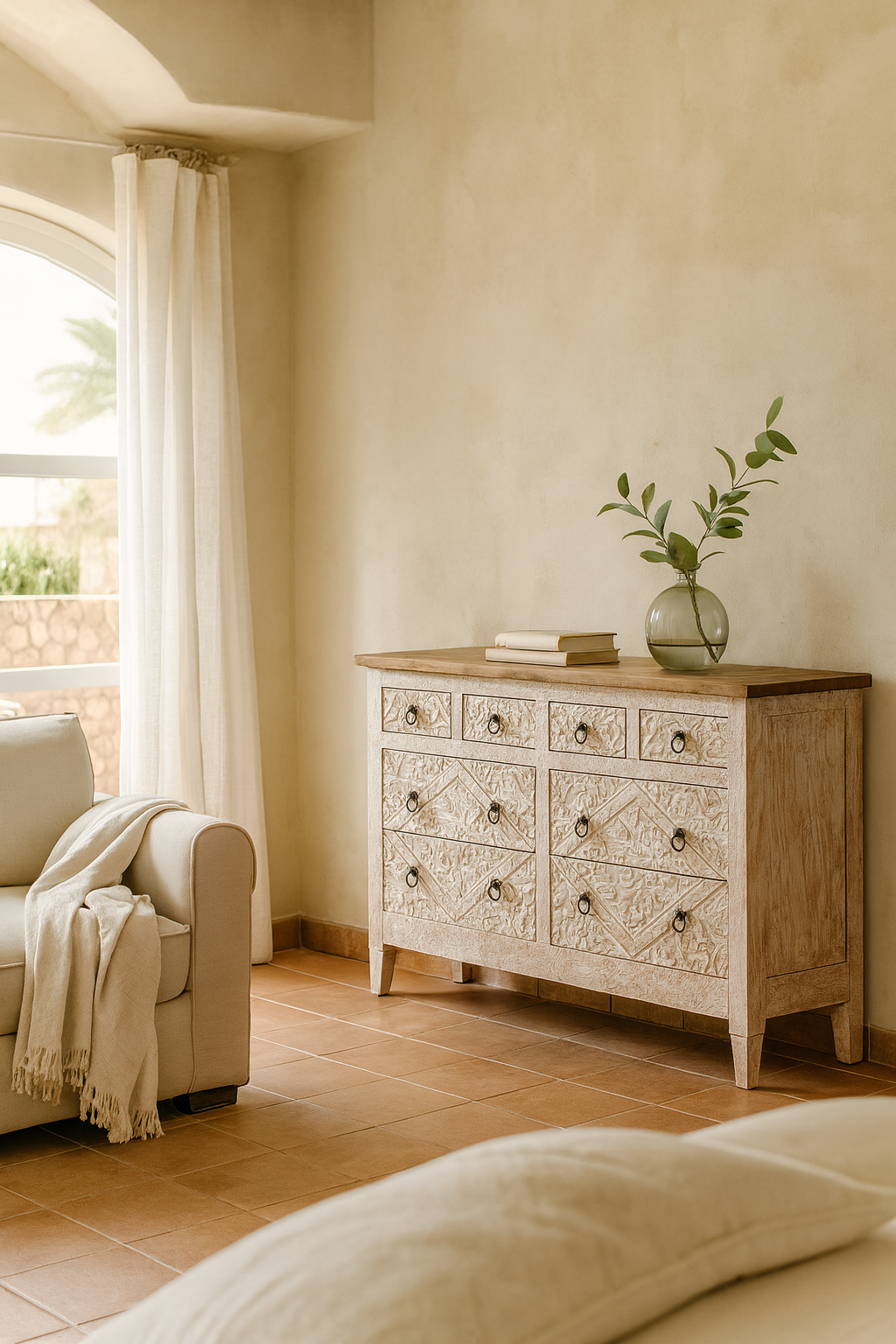 Wooden dresser with decorative patterns in a room with a couch and window.