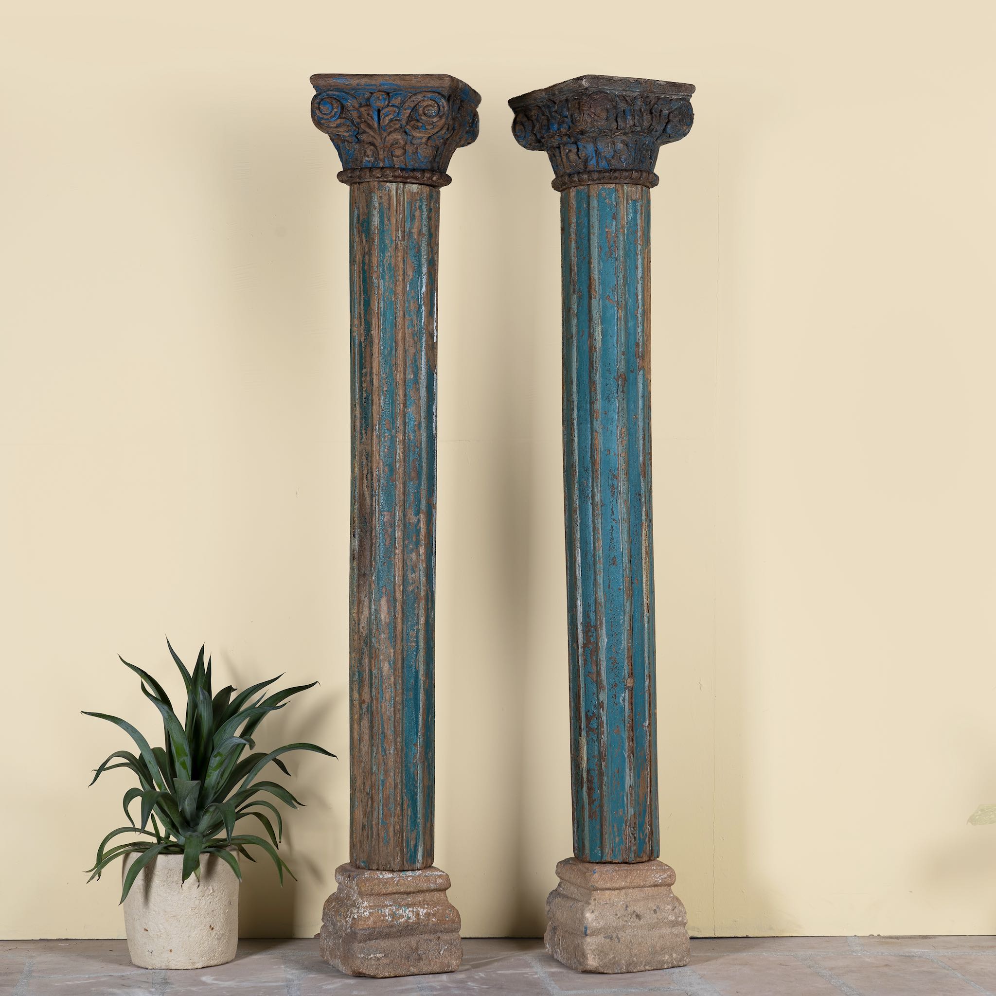 Antique pair of carved wooden house pillars with original stone bases, weathered multicolour finish, 210 cm high, vintage home decor and boho chic living room accents.