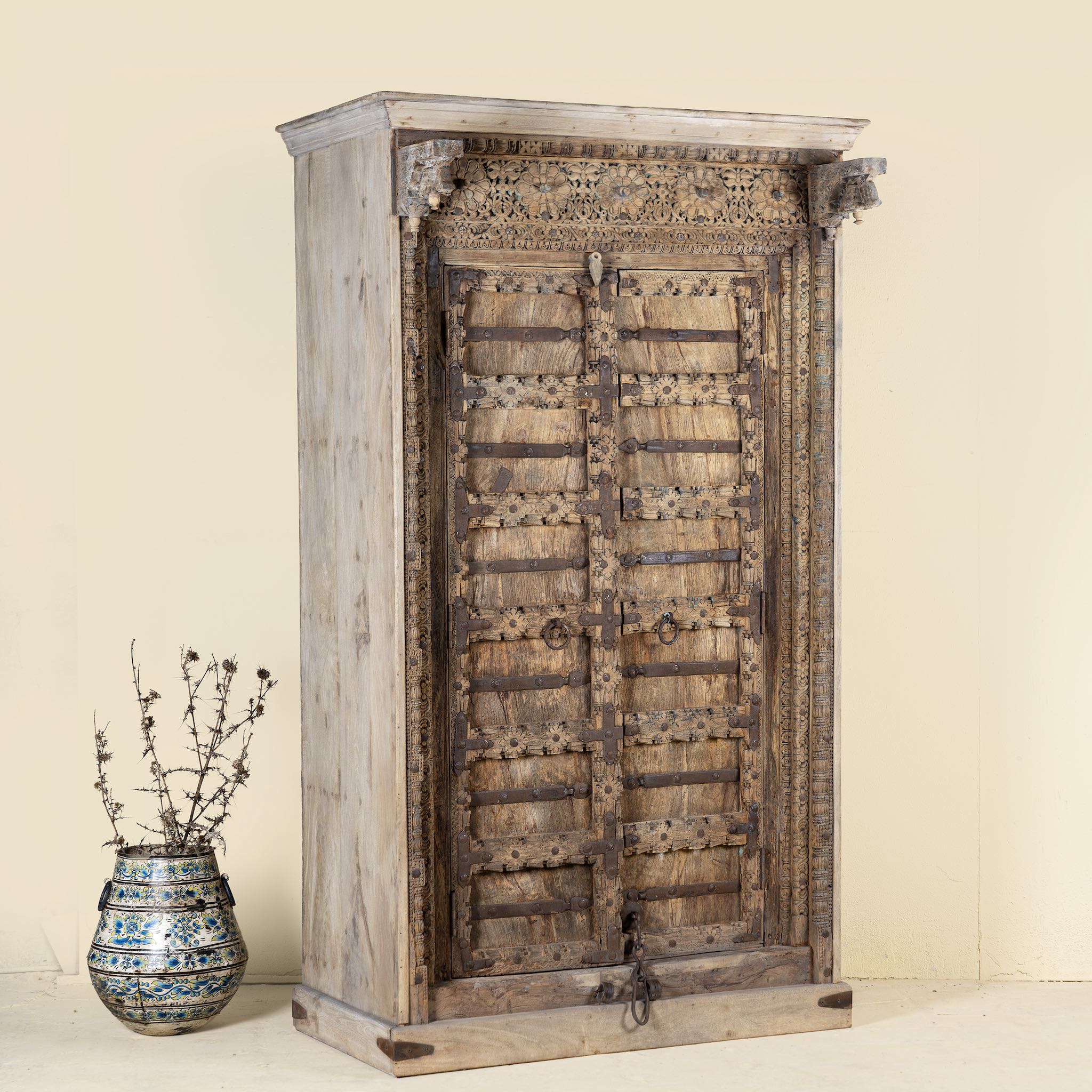 Side angle picture of a unique wardrobe with antique carved teak door, part of our teak wood furniture collection, perfect for a bohemian interior.