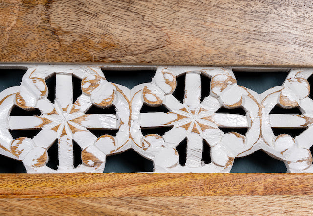 Close up image of a hand carved mango wood bench with floral backrest and spindle accents; rustic mango wood seating, 176 × 56 × 95 cm.