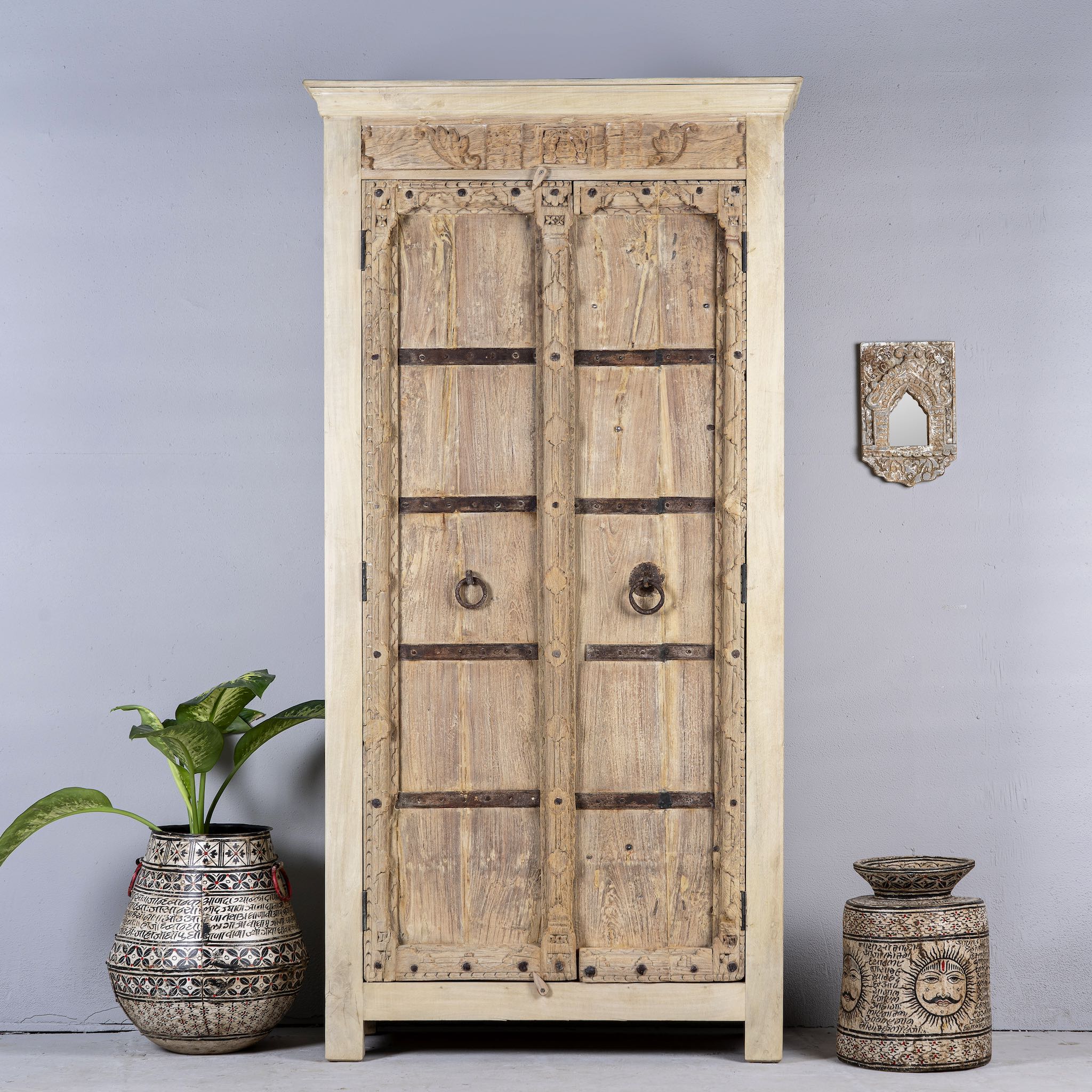 Front view image of a rustic solid wood wardrobe featuring vintage reclaimed door panels with iron accents and ring pull handles.