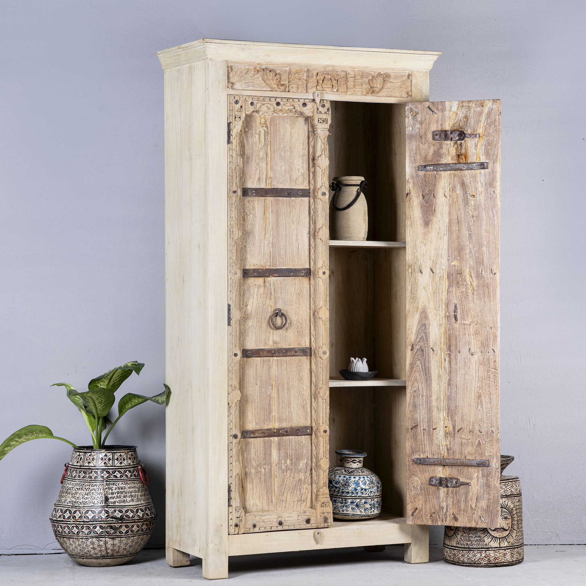 Open door image of a rustic solid wood wardrobe featuring vintage reclaimed door panels with iron accents and ring pull handles.