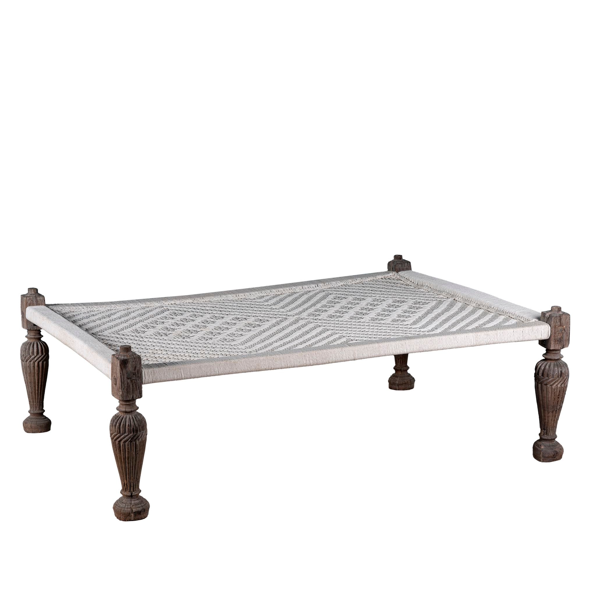 White background photo of a handwoven Indian Charpoi bed with reclaimed teak frame and carved legs; perfect for Indian home decor, 174 × 122 × 60 cm.