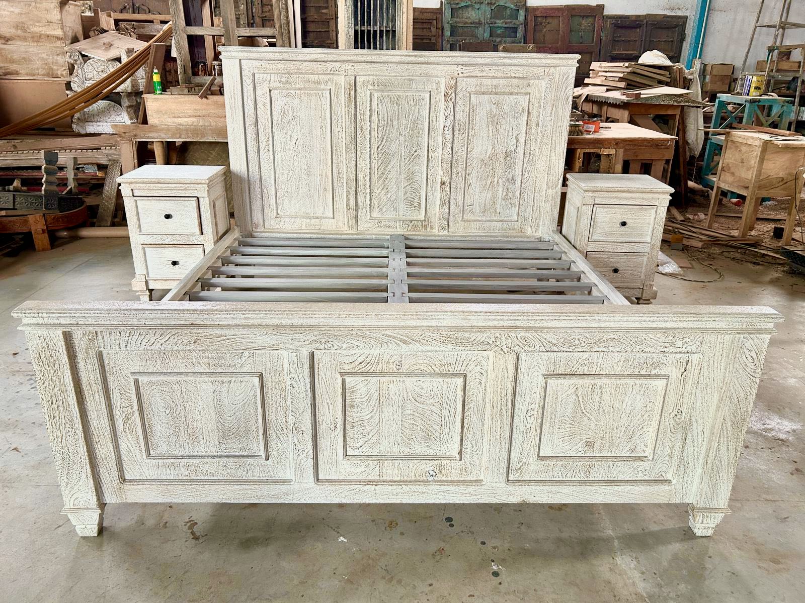 Wareheouse shoot of a whitewashed mango wood bed frame with carved panel design and two matching nightstands; rustic bedroom furniture set, bed size 180×200×140 cm, nightstands 50×40×65 cm.