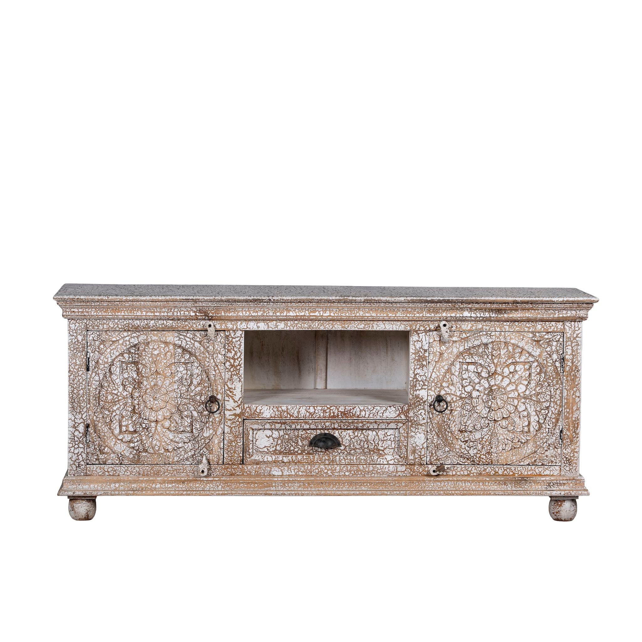 White background image of a carved mango wood lowboard with floral doors, crackled vintage finish, drawer, and open shelf, 150 × 40 × 64 cm.