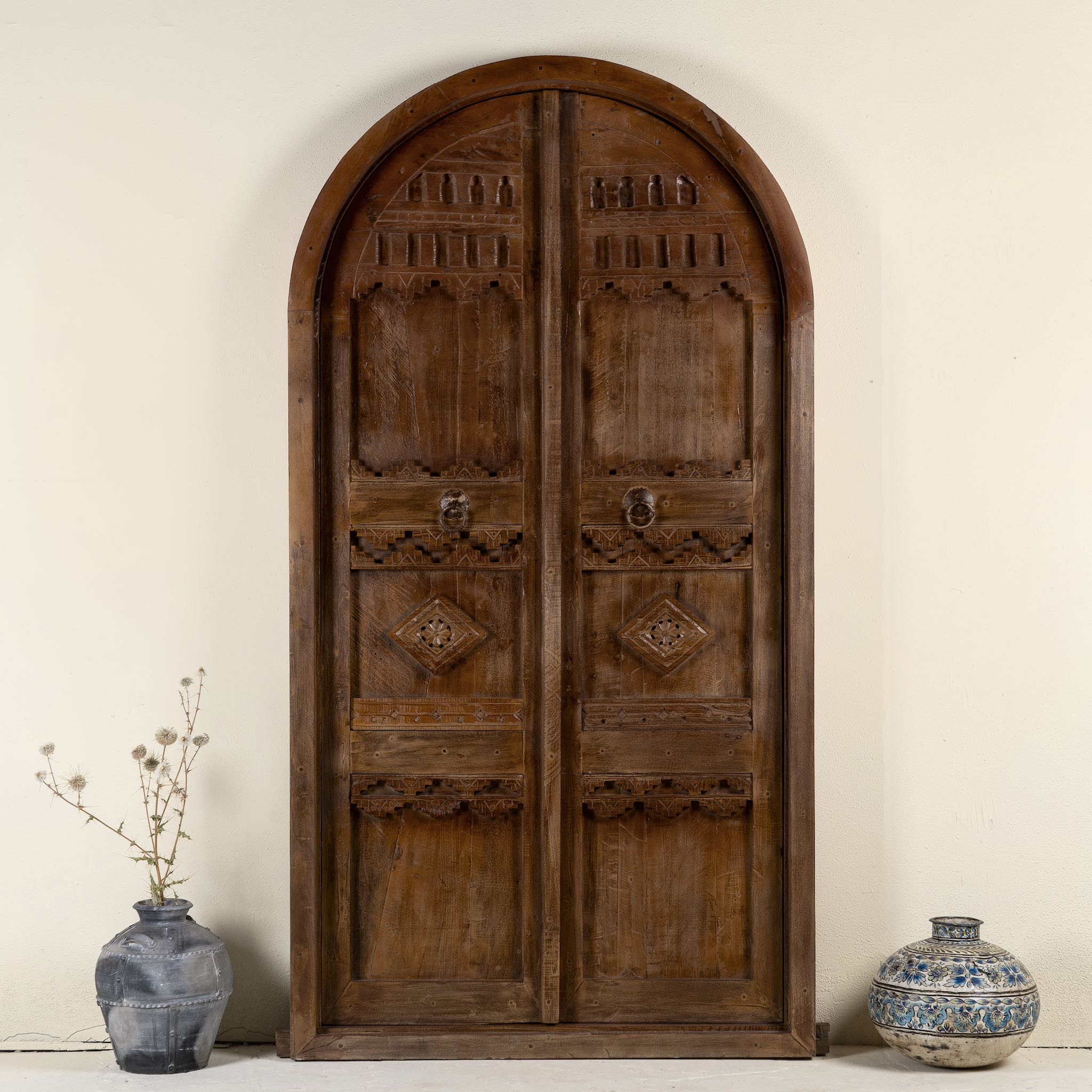 Front view image of an arched Moroccan-style door with frame made from reclaimed wood, featuring hand-carved details and a natural aged finish, suitable for wall décor or inbuilt installation.
