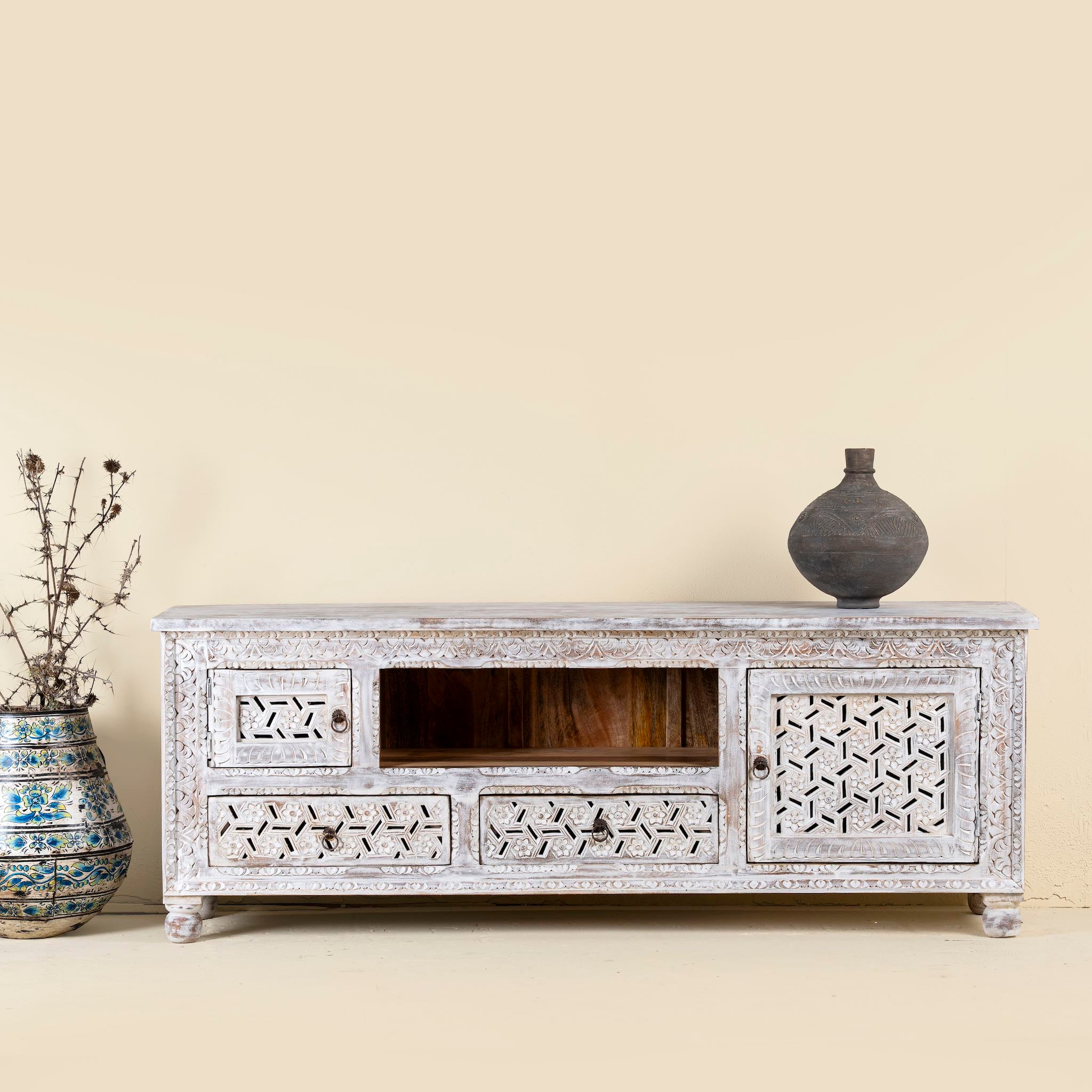 Lifestyle image of a hand-carved mango wood TV unit Pari in Mediterranean style, versatile living room furniture with drawers and compartments, 170 × 60 × 37 cm.