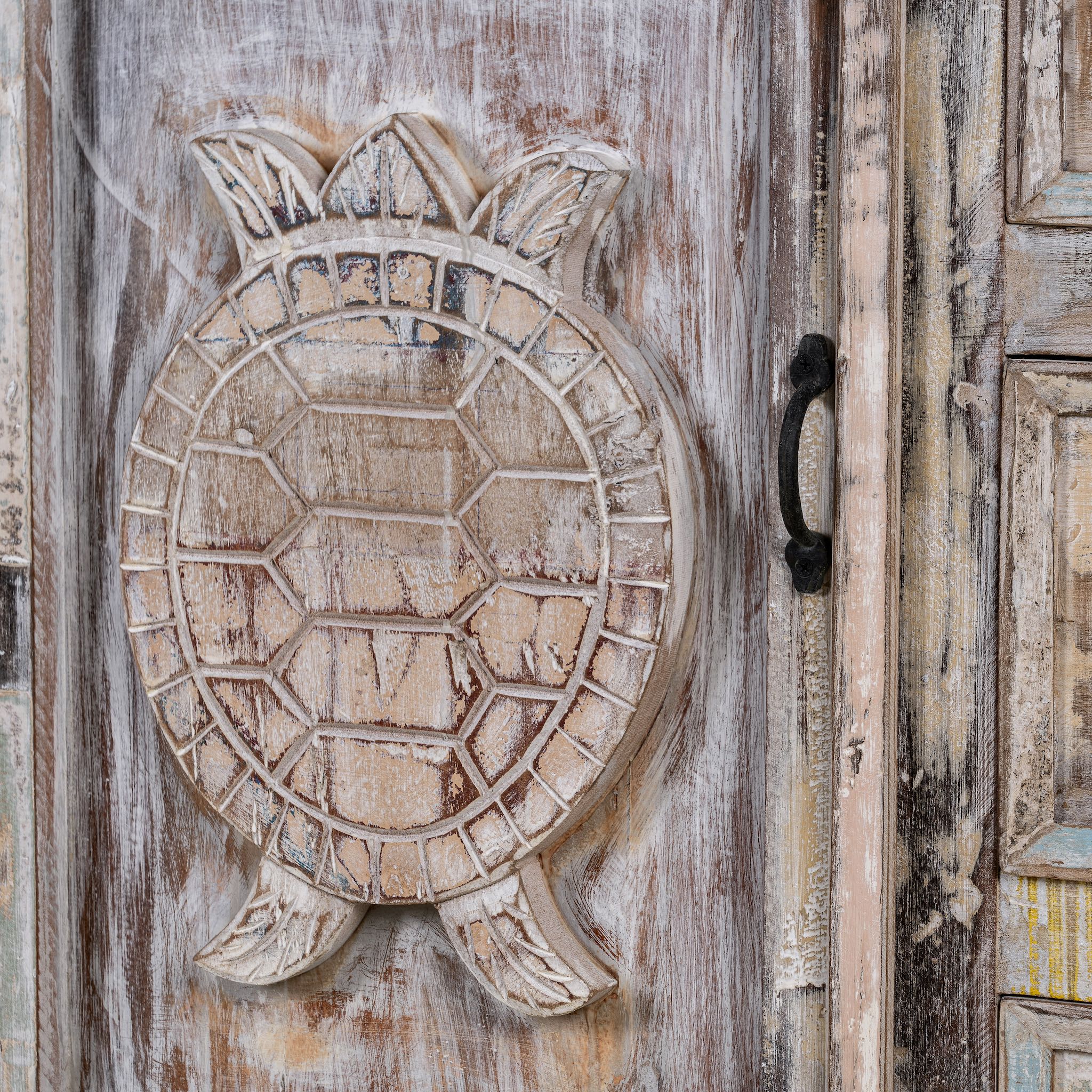 Close up image of a handcrafted cupboard made from reclaimed wood with a carved turtle motif and pastel finish; vintage furniture and sustainable furniture, 110 × 96 × 40 cm.