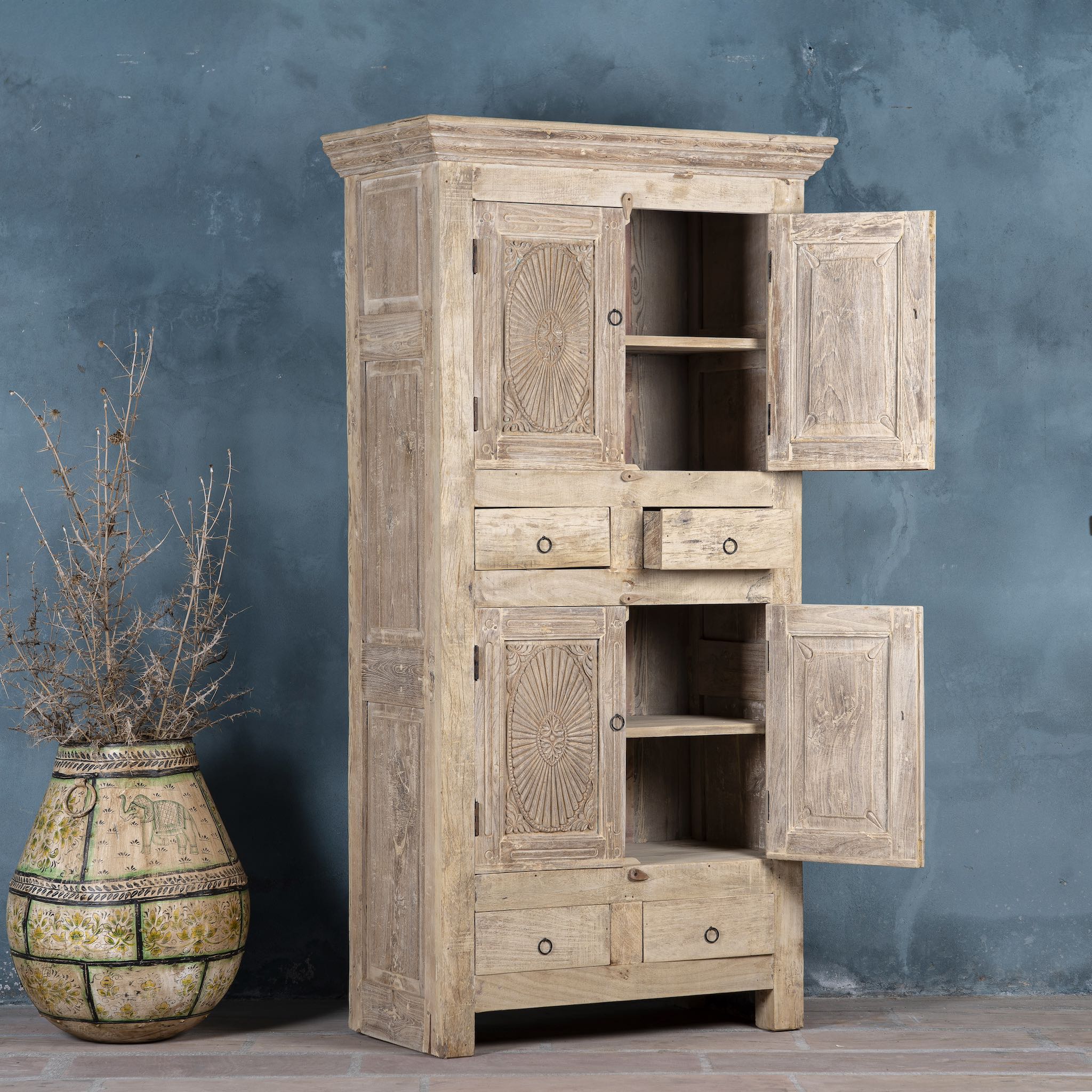 Open door image of a handcrafted wooden carved wardrobe with antique panel doors – teak wood furniture with rustic charm and traditional detailing.